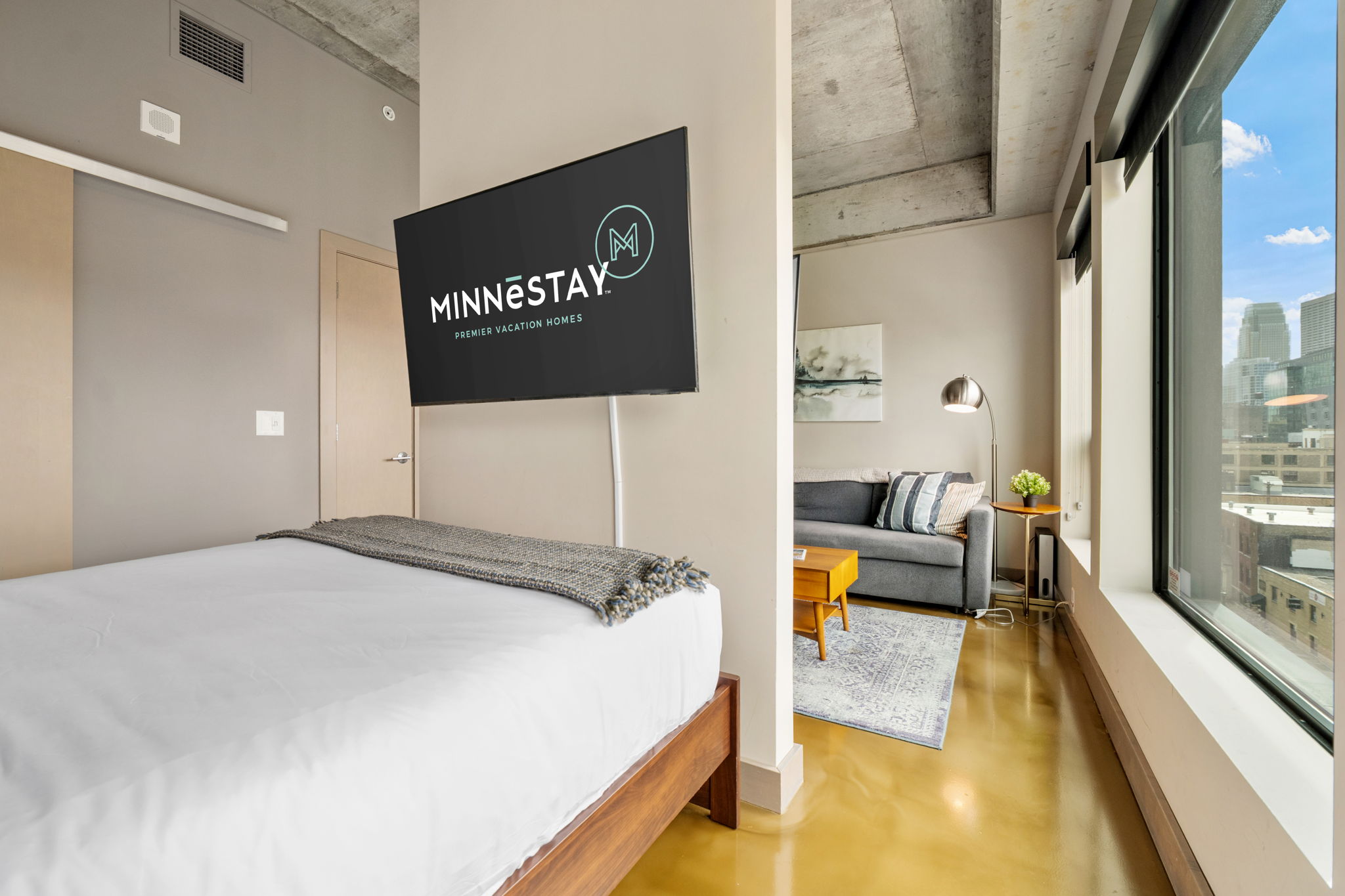 Modern apartment bedroom with inviting living area and city views.