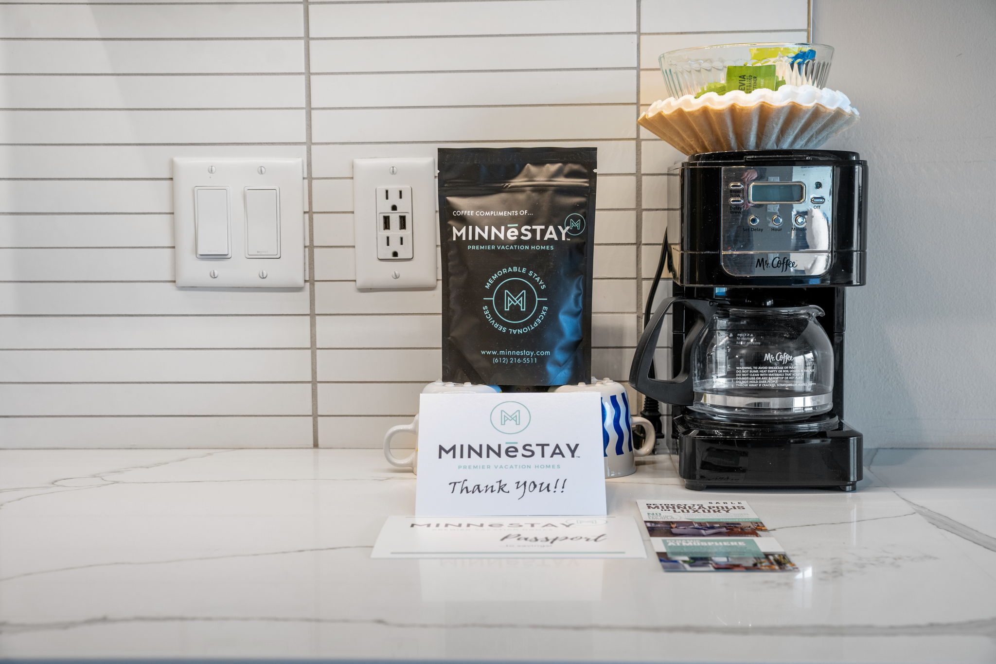 A modern coffee station featuring 'MINNESTAY' coffee essentials.