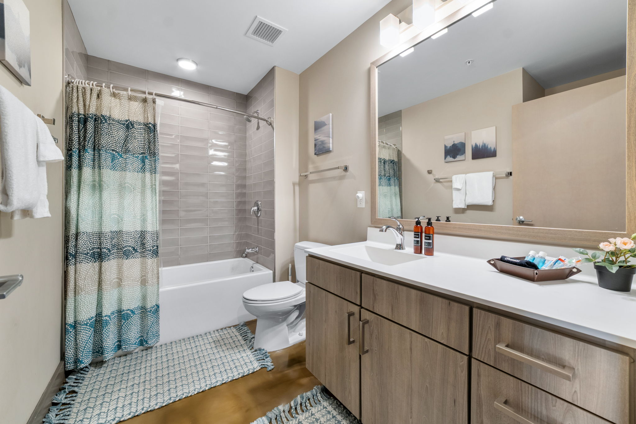 A modern bathroom featuring a stylish bathtub, elegant vanity, and vibrant shower curtain.