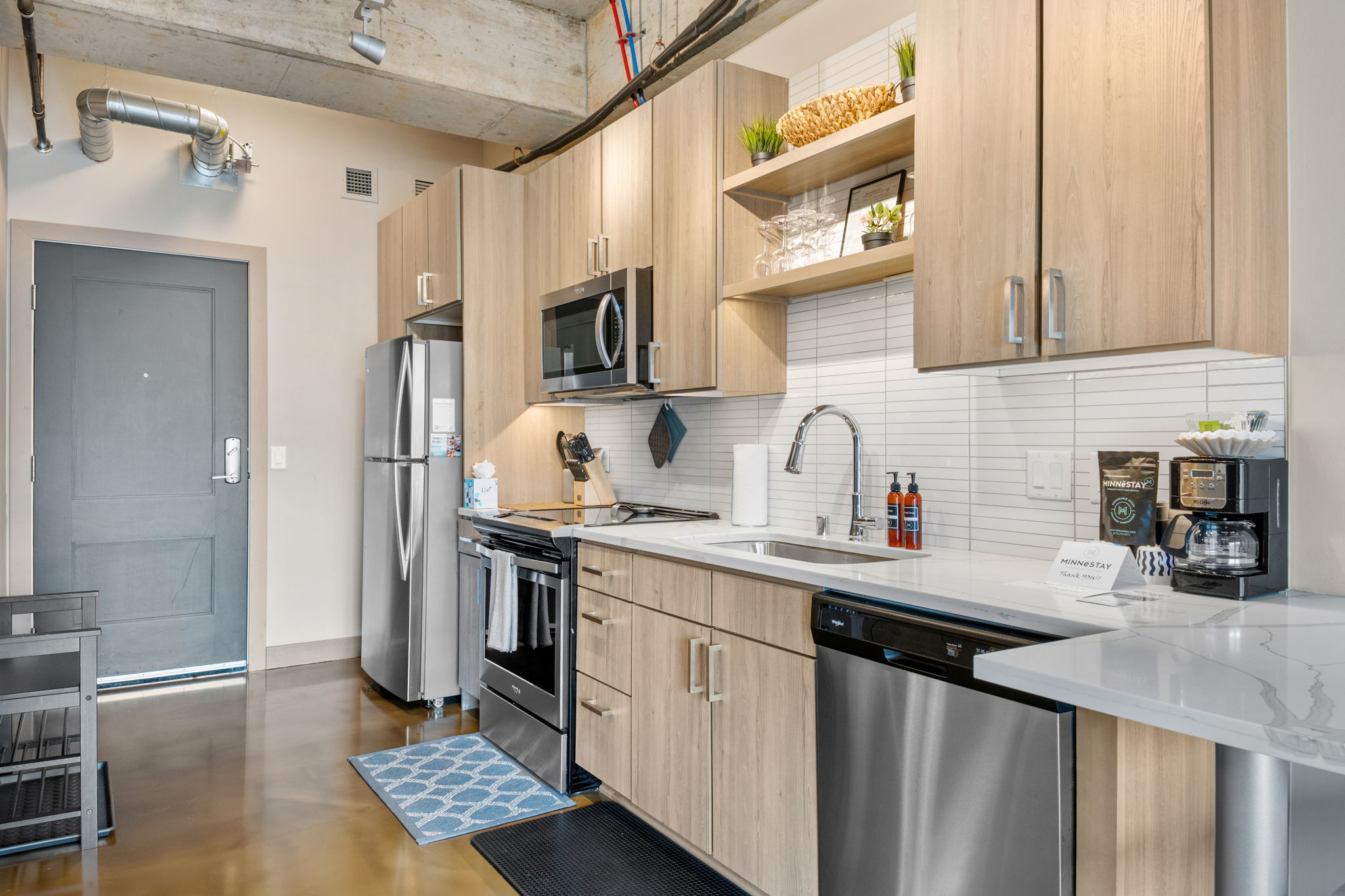 Modern kitchen featuring light wood cabinetry and sleek appliances.