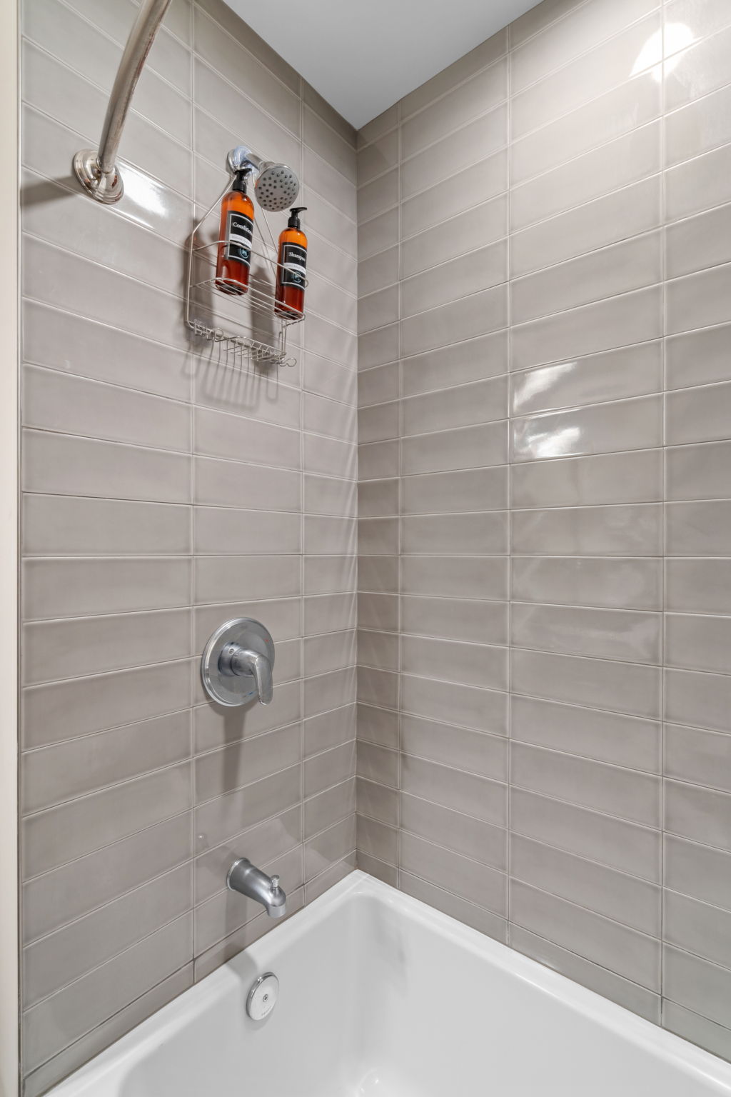 Modern shower setup with sleek tiles and bath essentials.