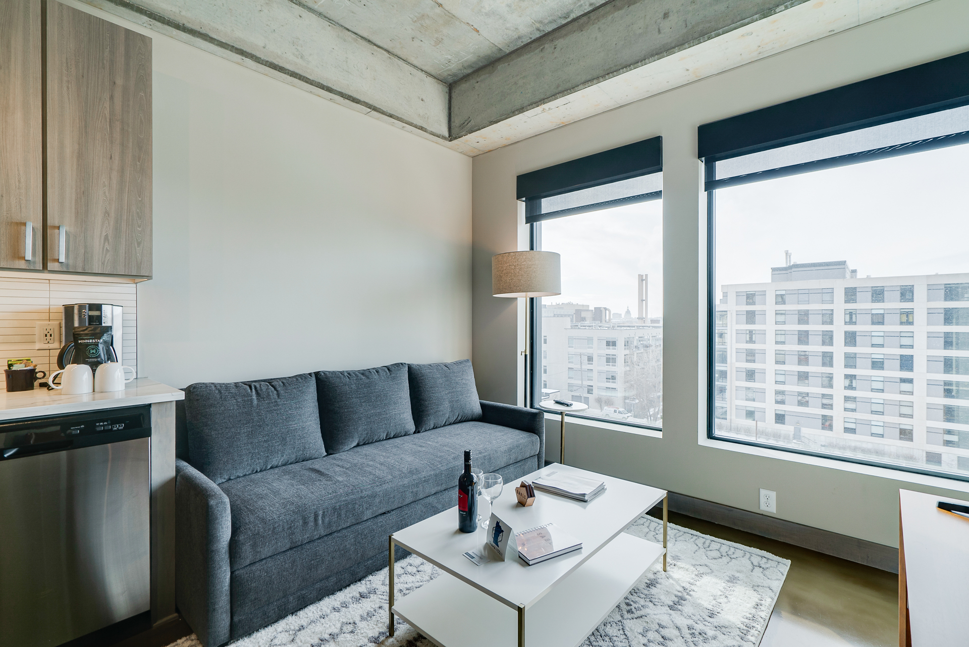 A contemporary urban apartment with a cozy living area and an industrial-style ceiling.