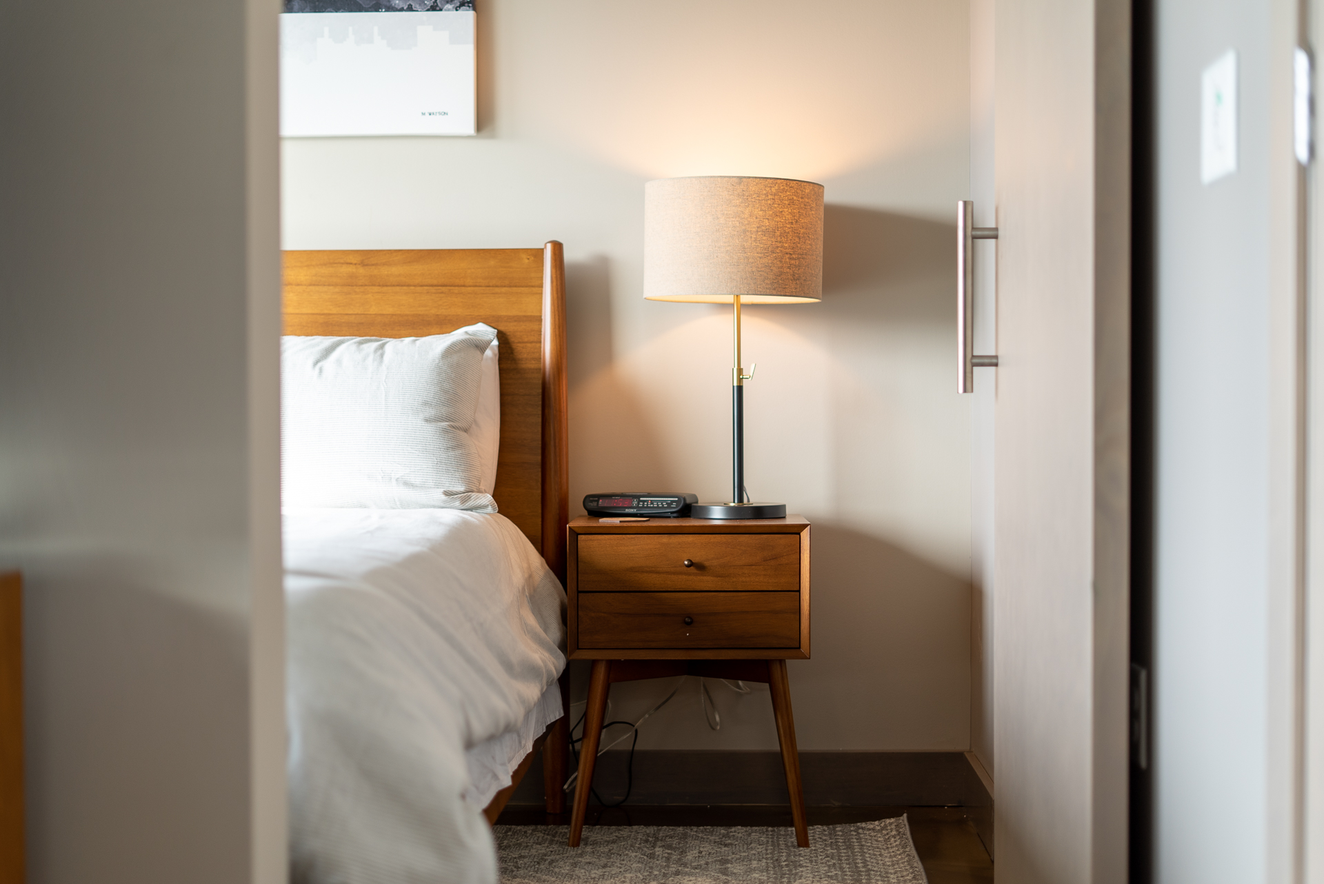 A cozy modern bedroom with a wooden bed and stylish nightstand.