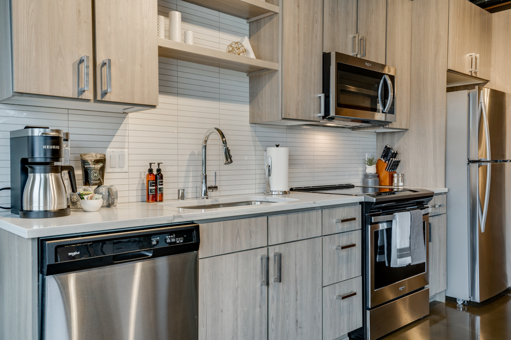 A stylish modern kitchen with light cabinetry and sleek appliances.