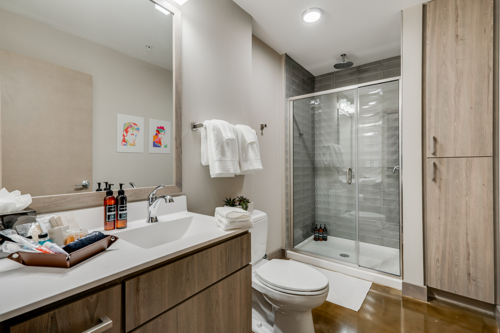 Modern bathroom with sleek design and colorful artwork.