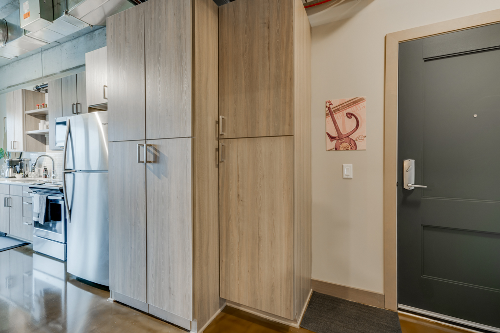A modern kitchen entrance with sleek cabinetry and a touch of art.