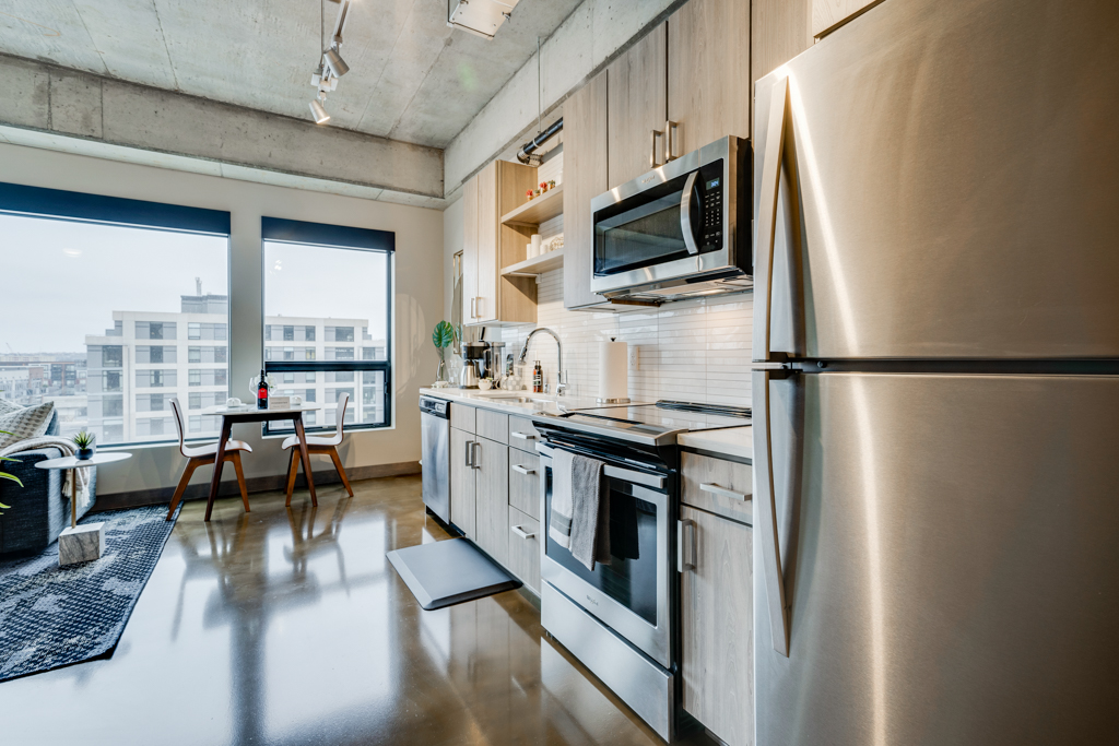 A modern kitchen featuring stainless steel appliances and a cozy dining area.