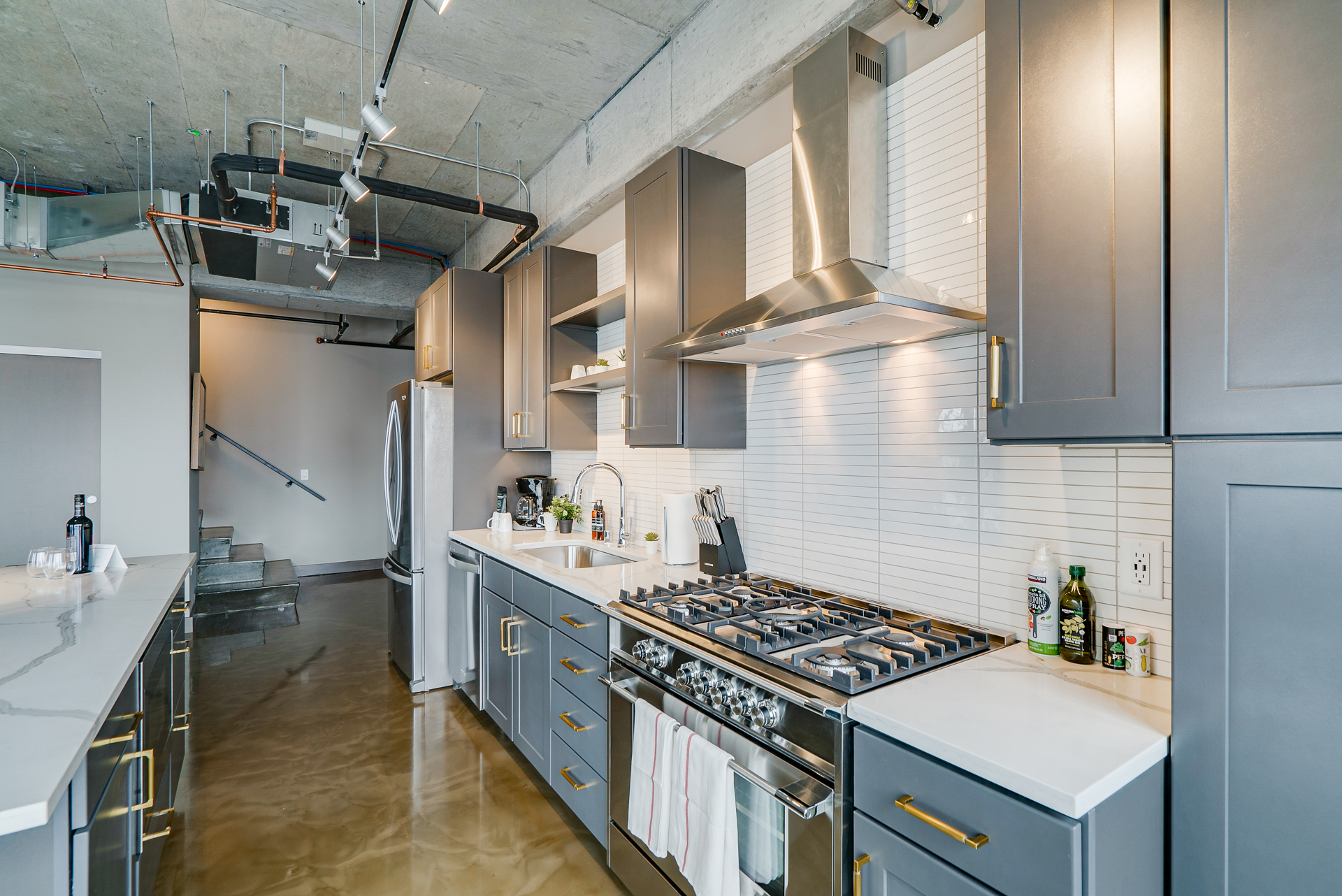 A modern kitchen featuring sleek cabinetry and a polished concrete floor.