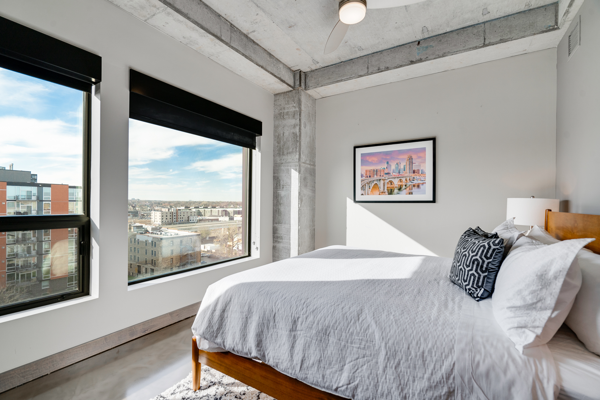 A modern bedroom with urban views and stylish decor.