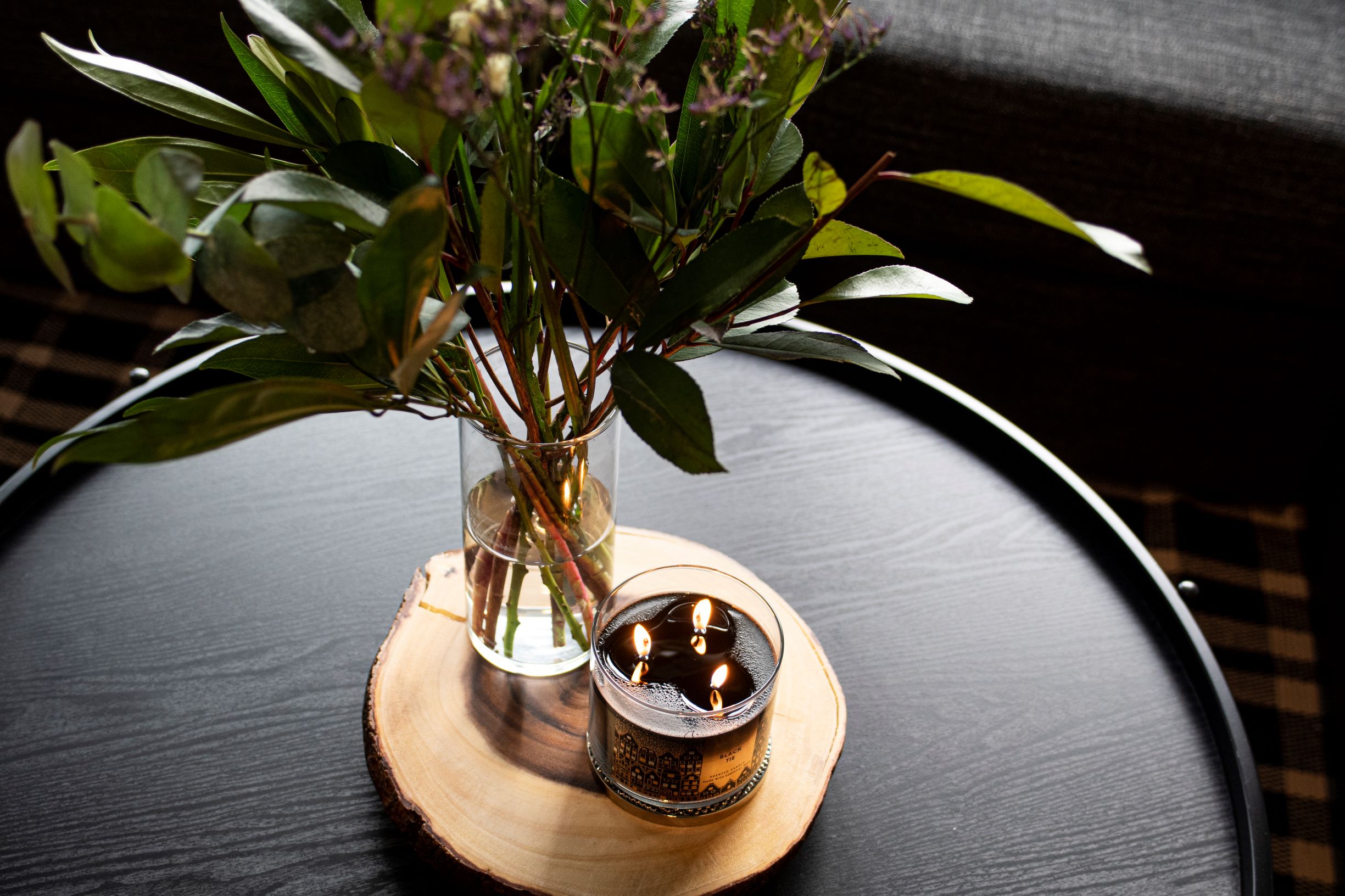 A serene tabletop scene featuring a floral arrangement and a scented candle.