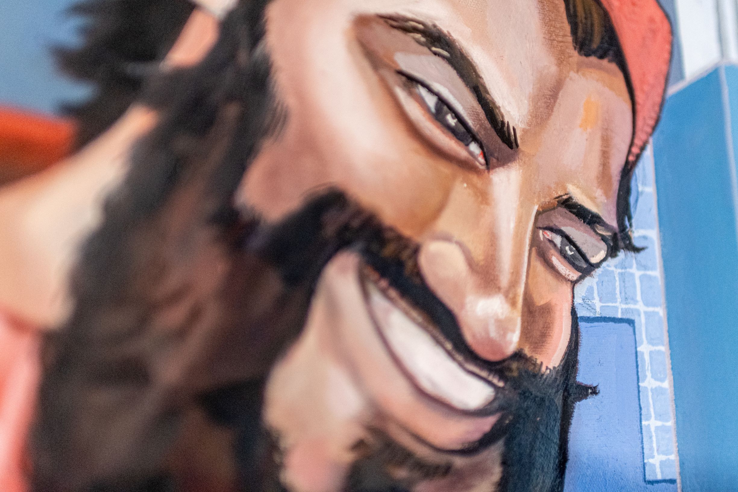 Close-up of a joyful man with a beard and red cap.