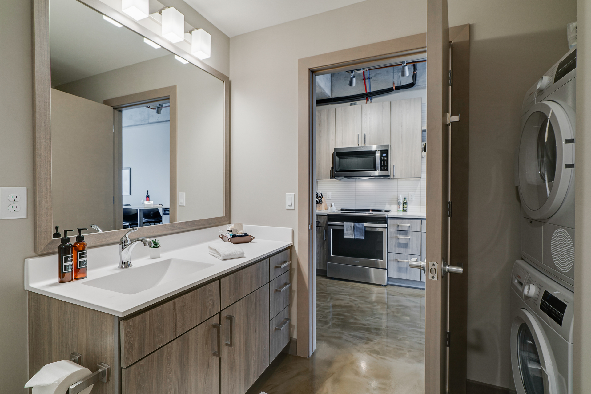 A modern bathroom adjacent to a stylish kitchen with integrated laundry.