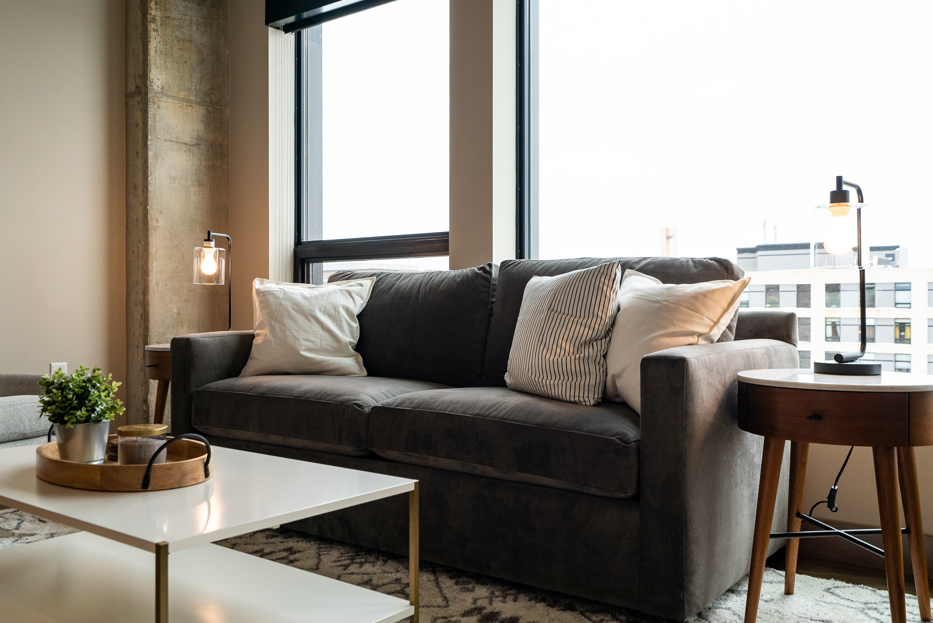A cozy urban living room featuring a gray couch and stylish decor.