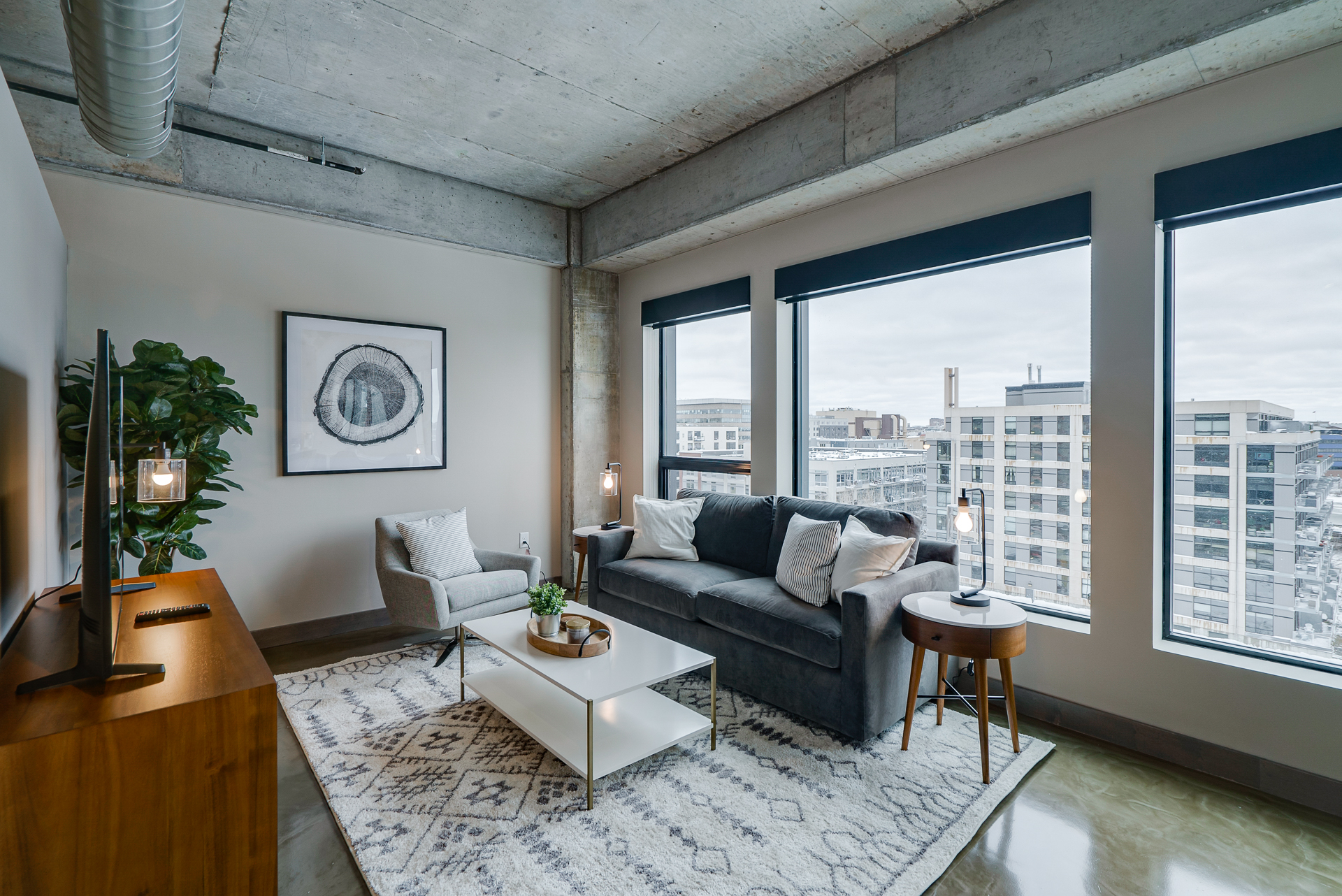 A cozy modern living room with industrial accents and urban views.