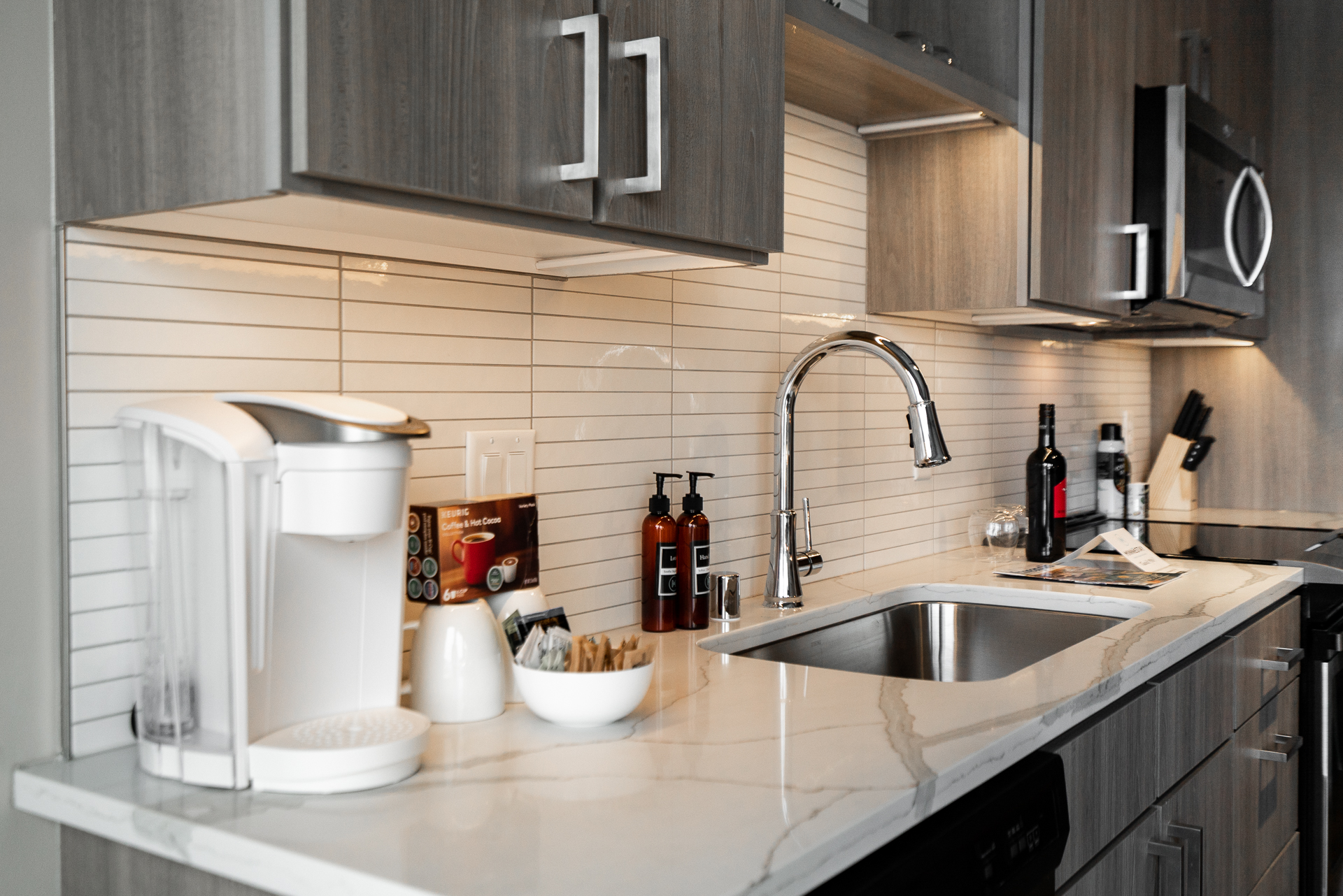A modern kitchen countertop featuring a coffee maker, elegant marble surface, and stylish fixtures.