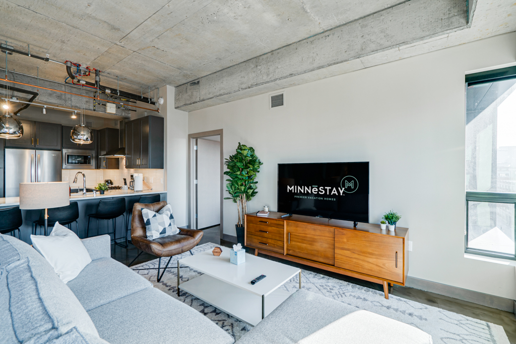 A stylish modern living space with a cozy sectional sofa and sleek kitchen design.