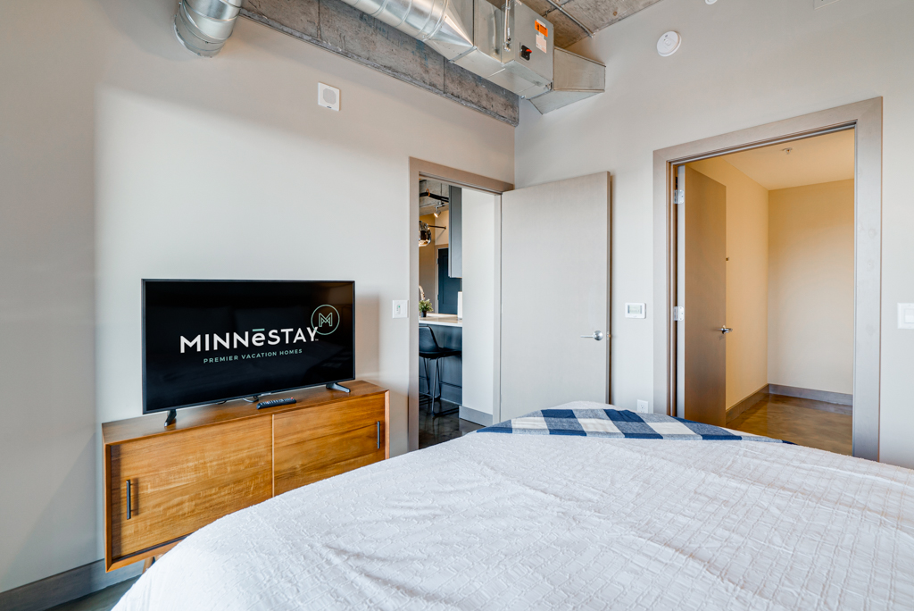 A modern bedroom showcasing a comfortable bed and stylish decor, ideal for vacation stays.