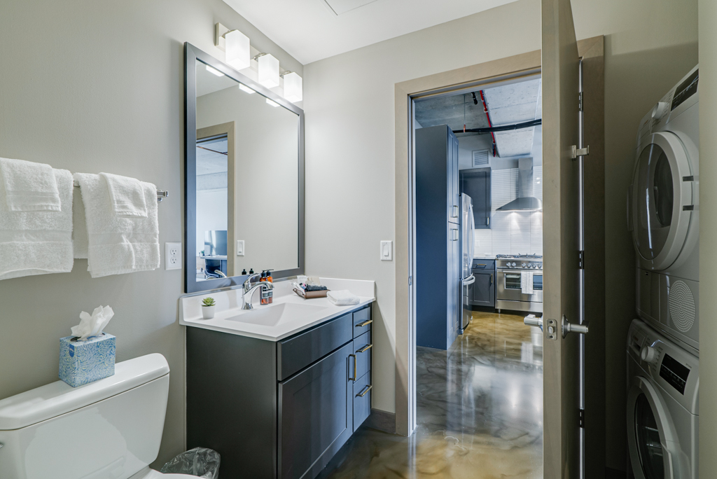 A contemporary bathroom transitioning into a sleek kitchen.