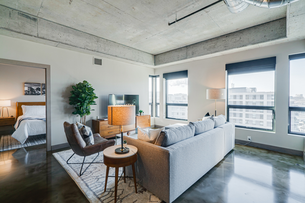 A bright and modern apartment living space with an open layout and industrial details.