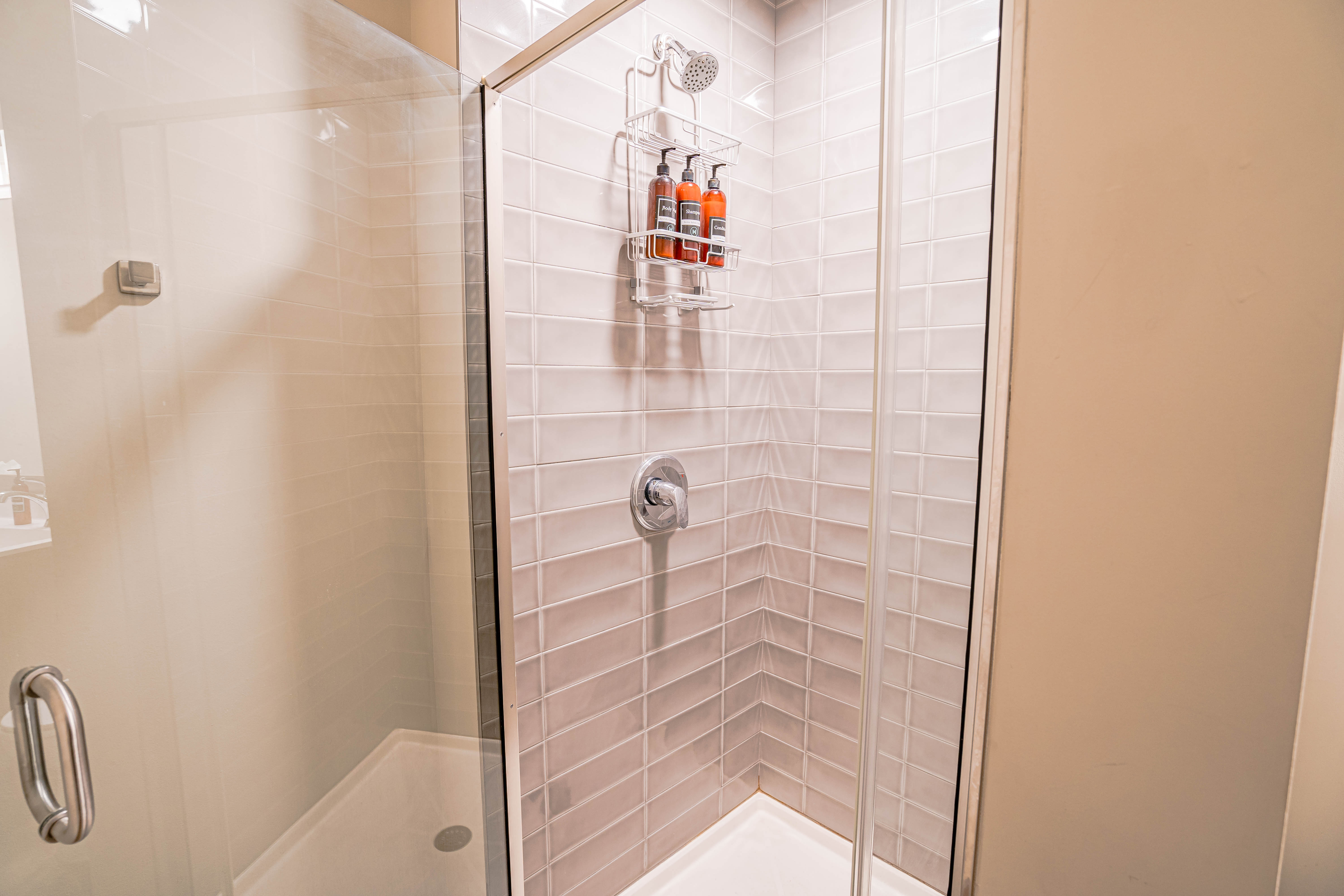 A modern shower with sleek tiles and organized shower products.