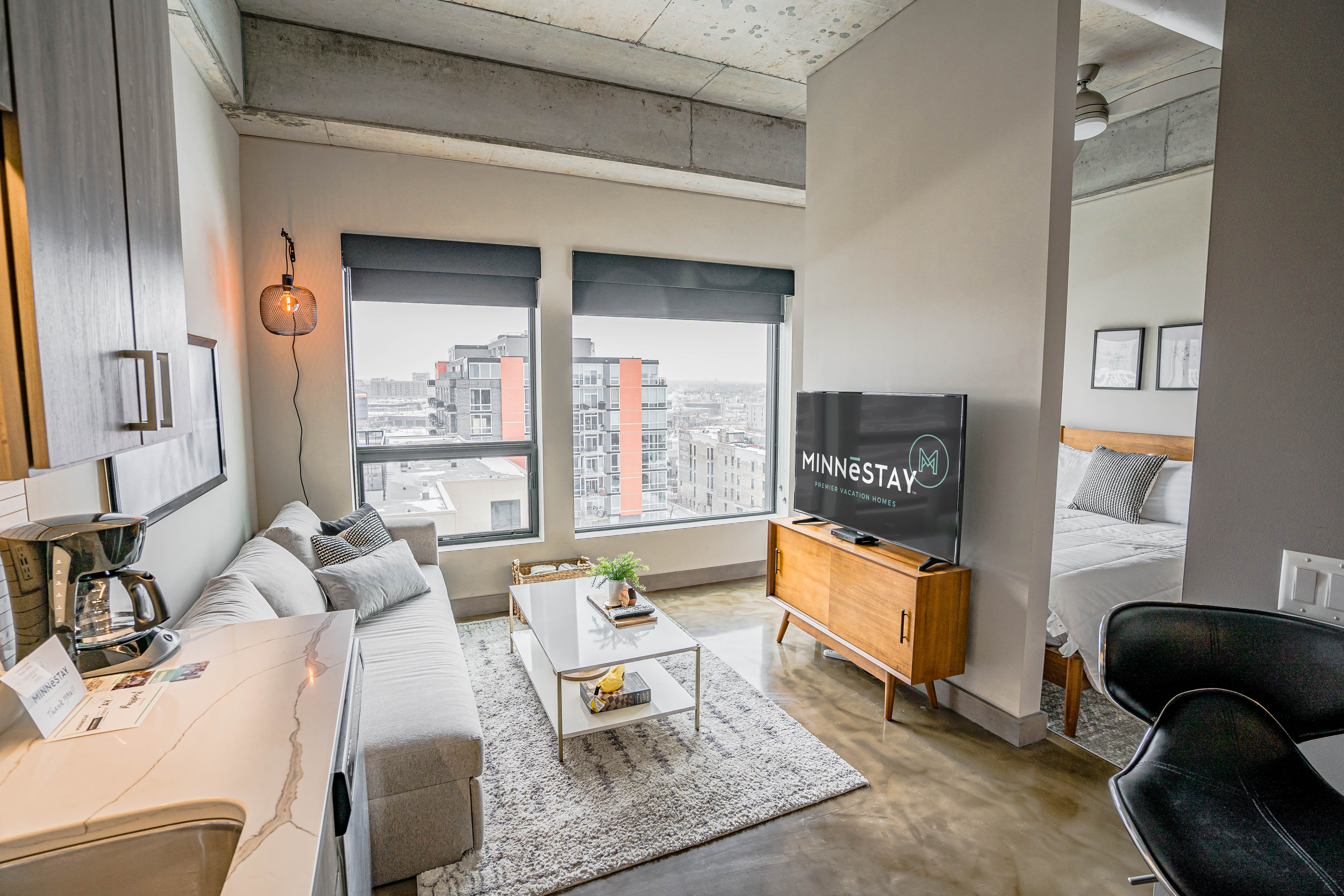 A modern studio apartment featuring a cozy living area and urban views.