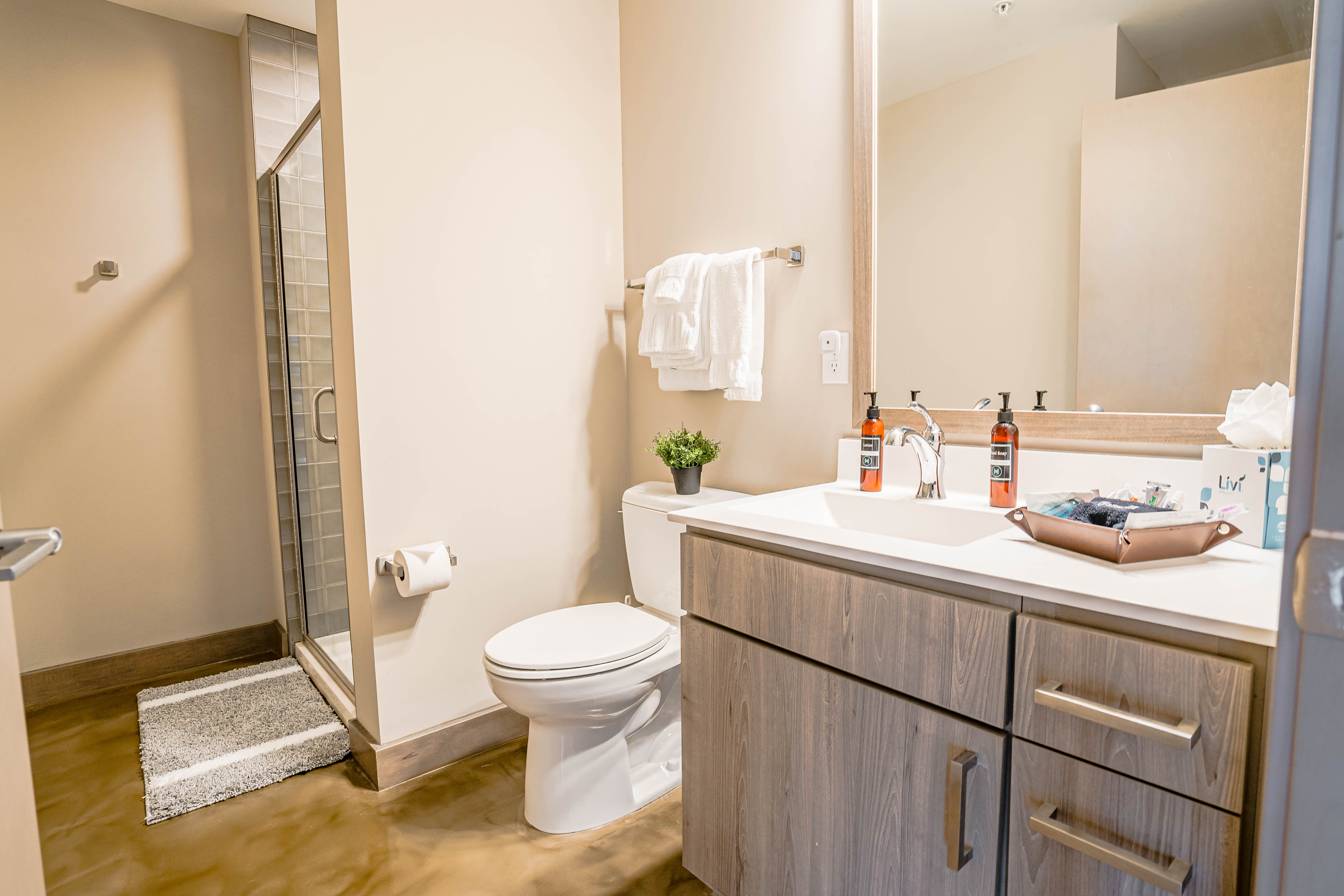 A modern bathroom featuring a sleek vanity and a glass shower enclosure.