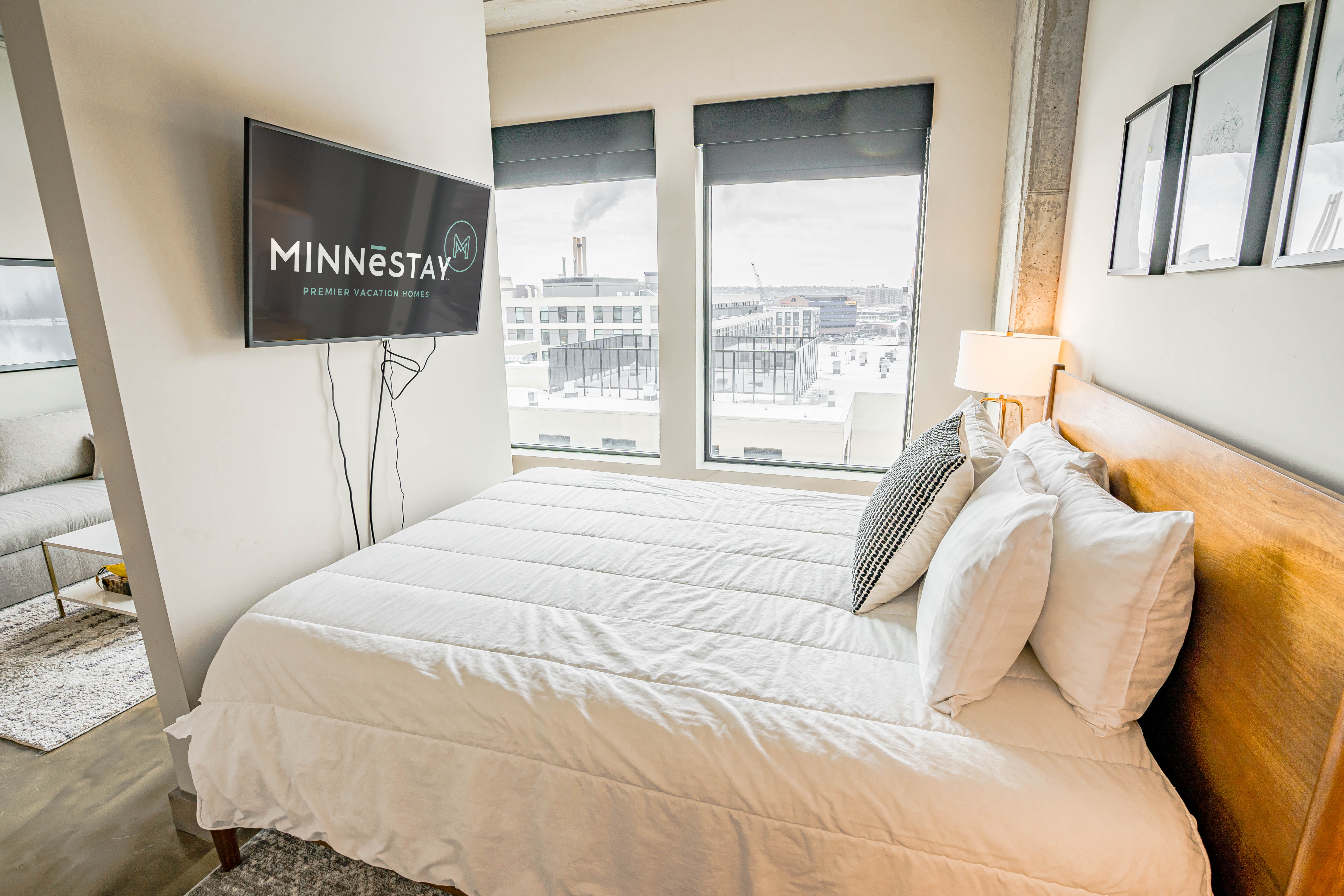 A modern bedroom featuring a comfortable bed and urban views.