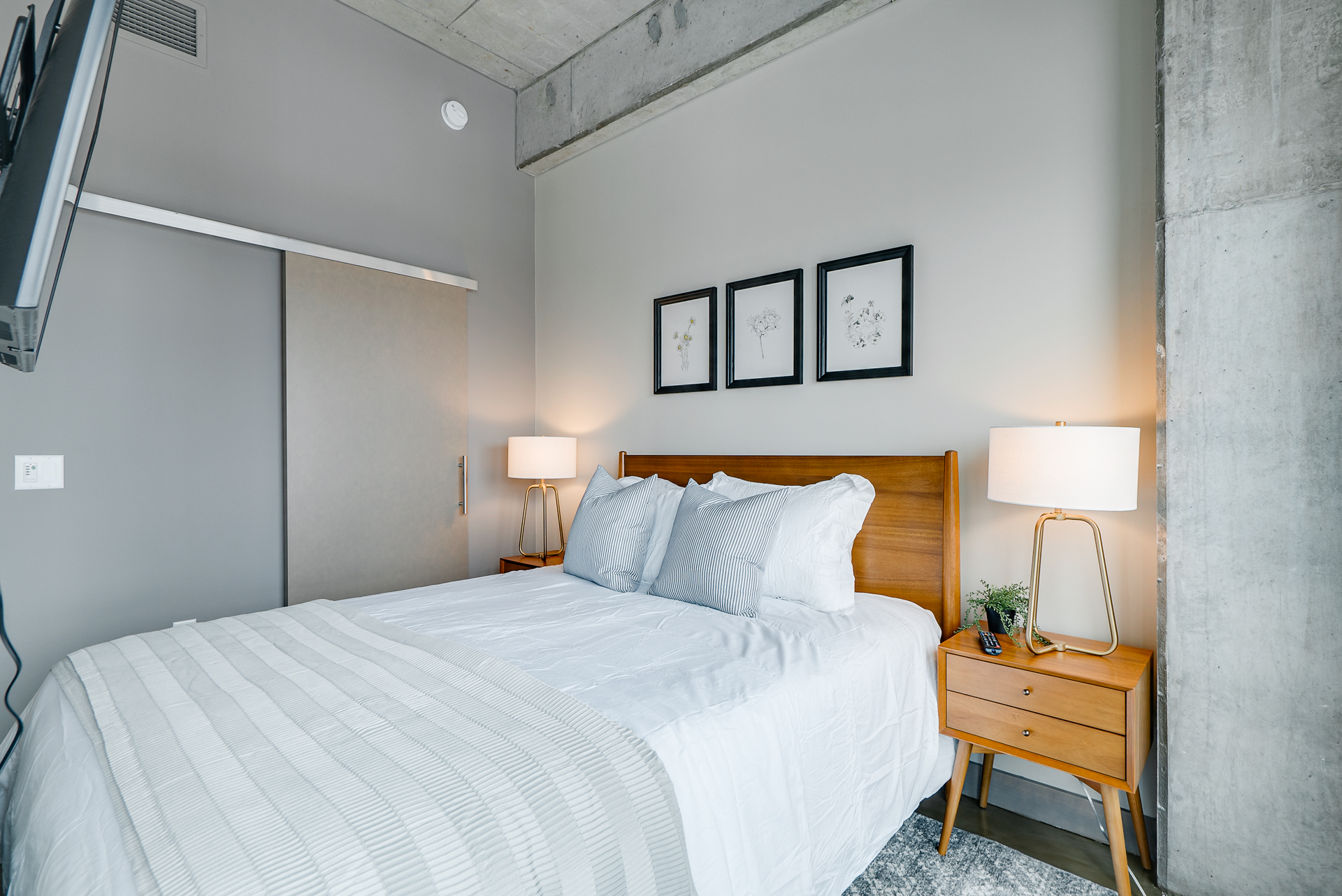 A modern and serene bedroom with wooden and concrete elements.