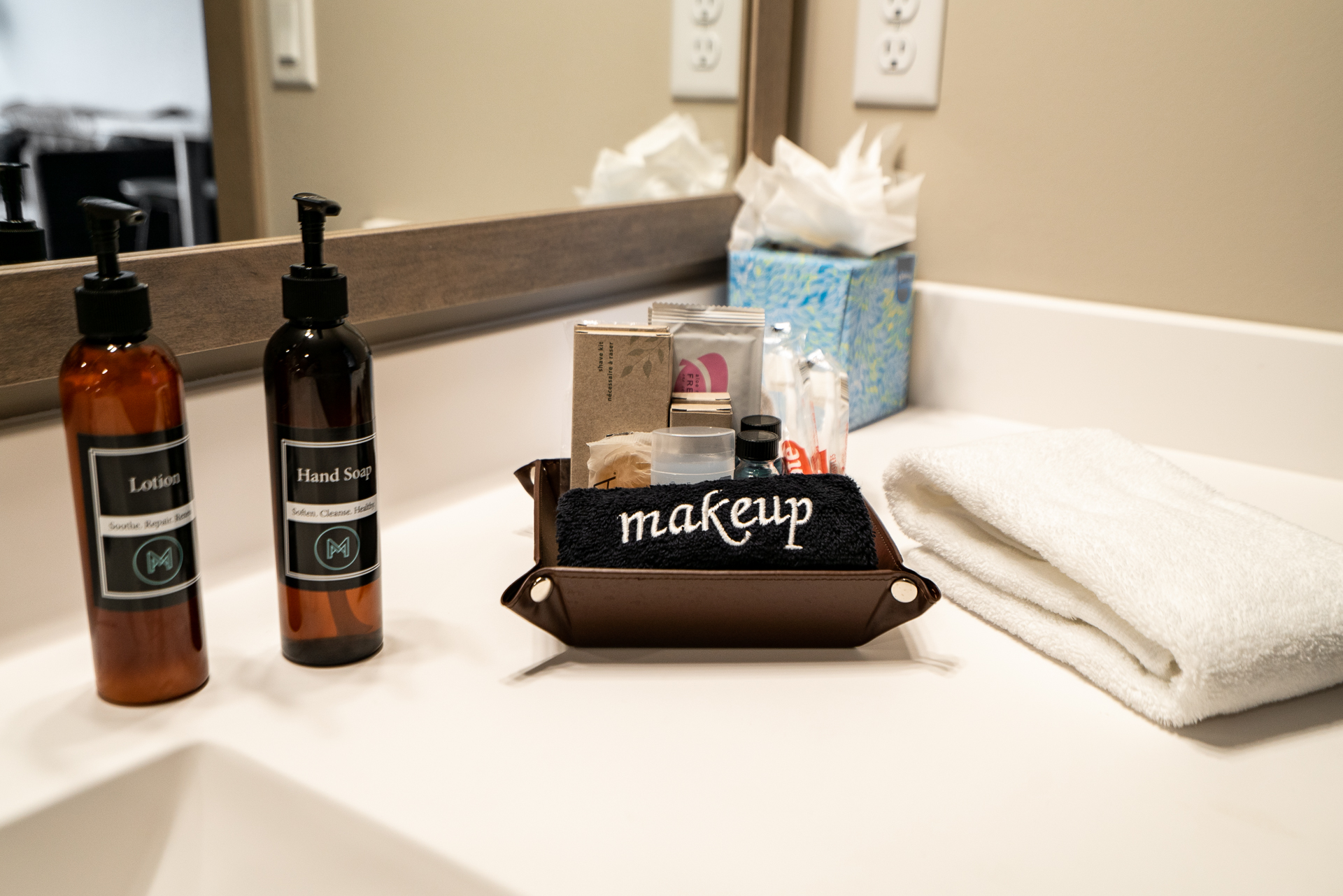 An organized bathroom countertop with beauty essentials and a cozy towel.