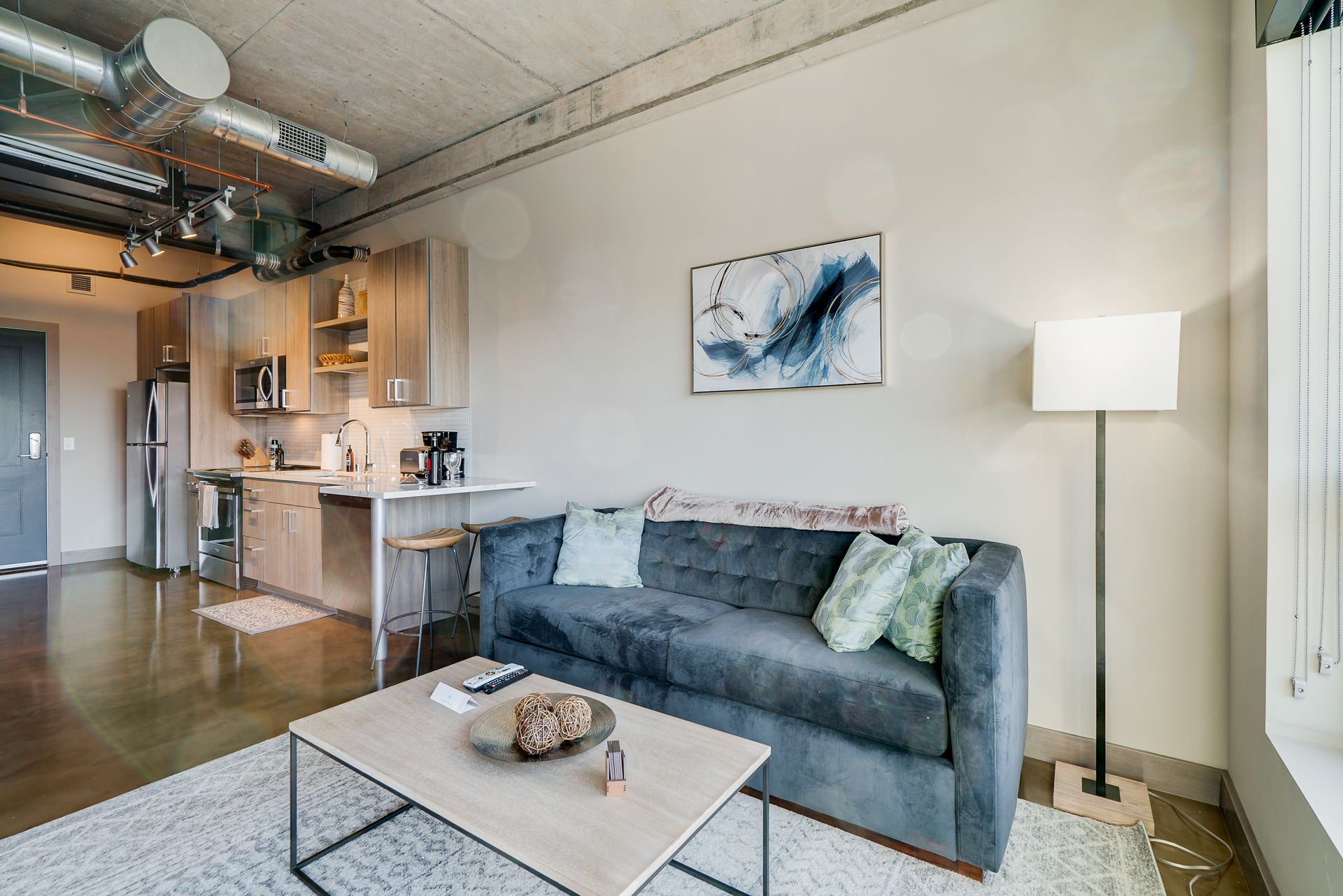 Modern urban living space with a stylish sofa and contemporary kitchen elements.