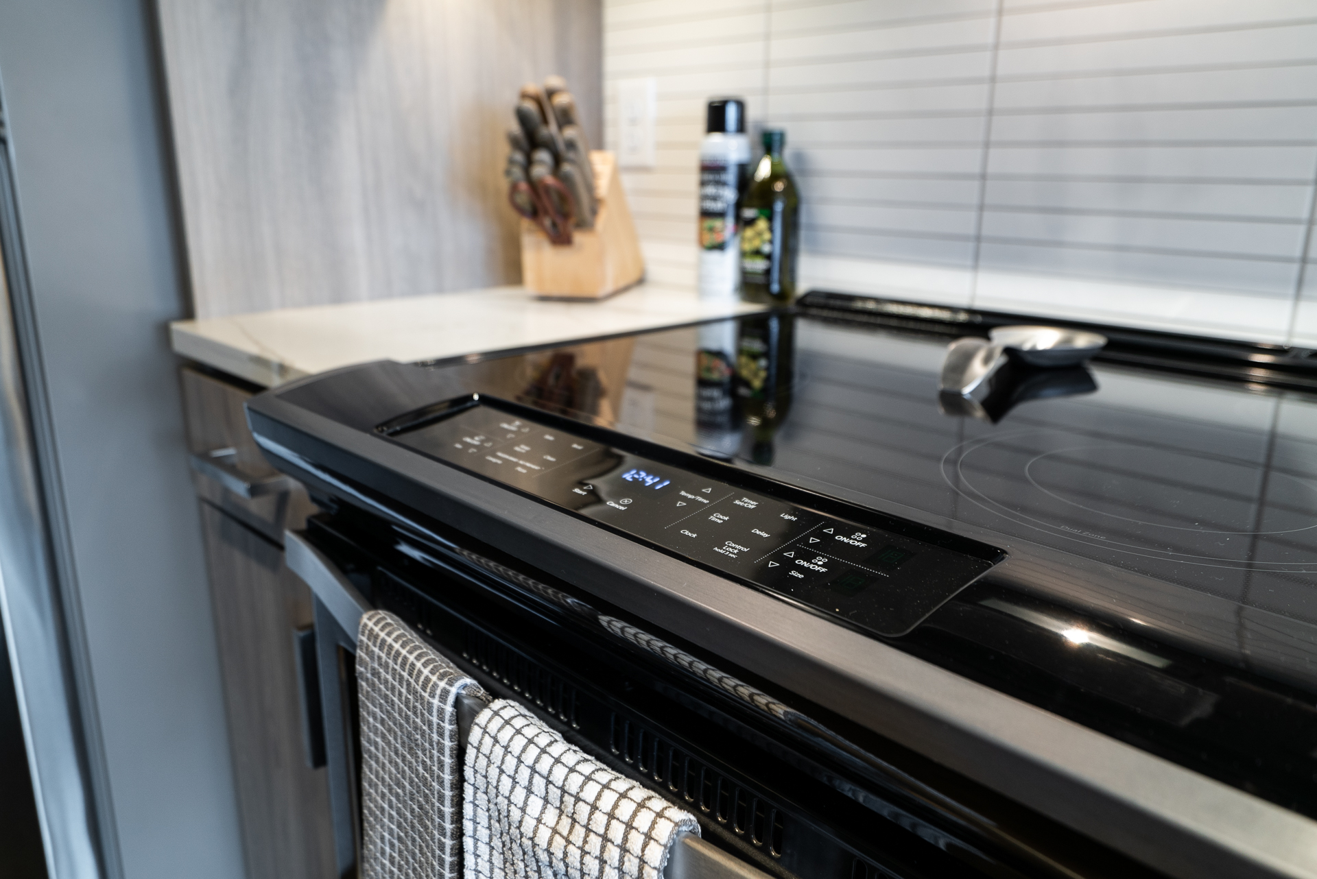 A modern kitchen showcasing a sleek black electric stove with a digital control panel.