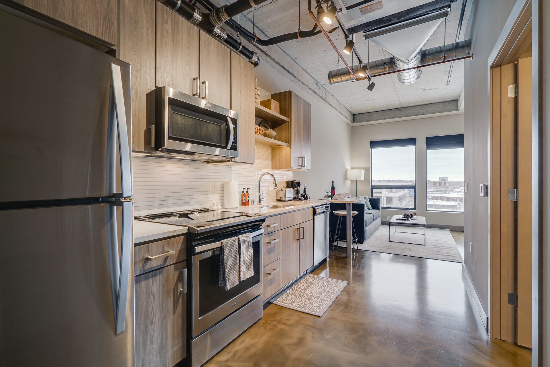Interior view of a contemporary kitchen with stainless steel appliances and a cozy living space.