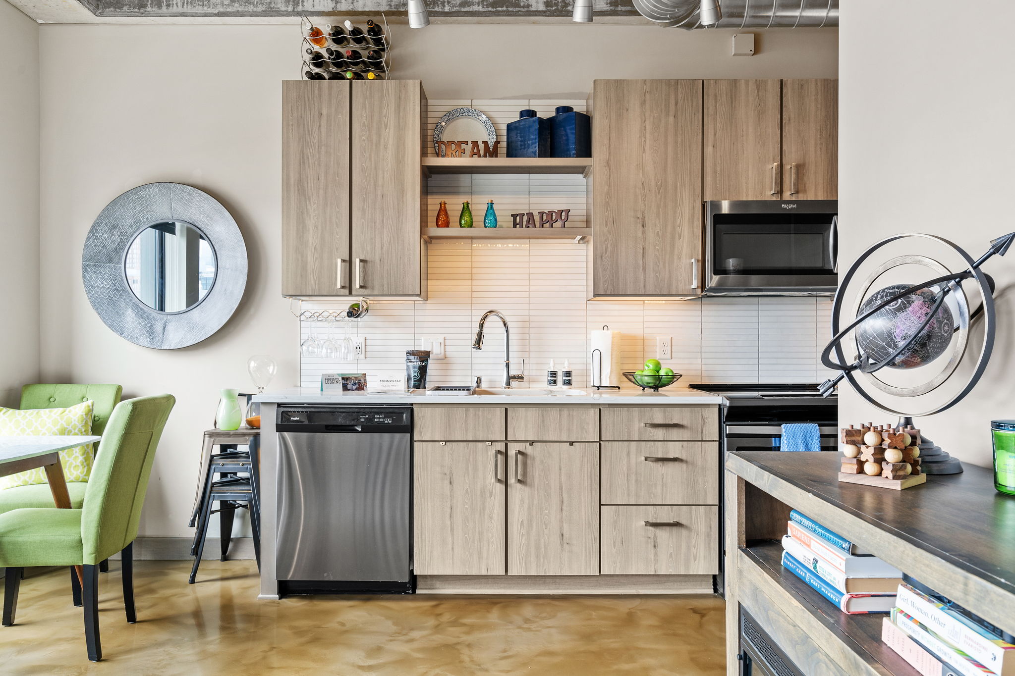 Modern kitchen in a stylish apartment, featuring wooden cabinets and colorful decorations.