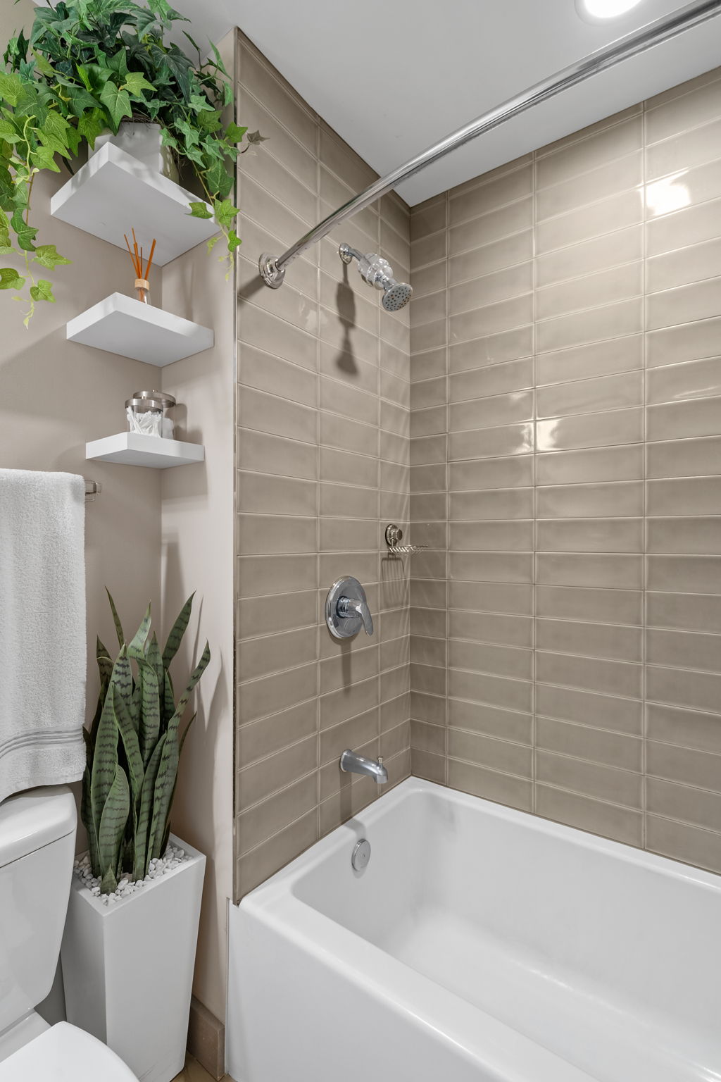 A modern bathroom featuring a sleek bathtub and stylish beige tiles.
