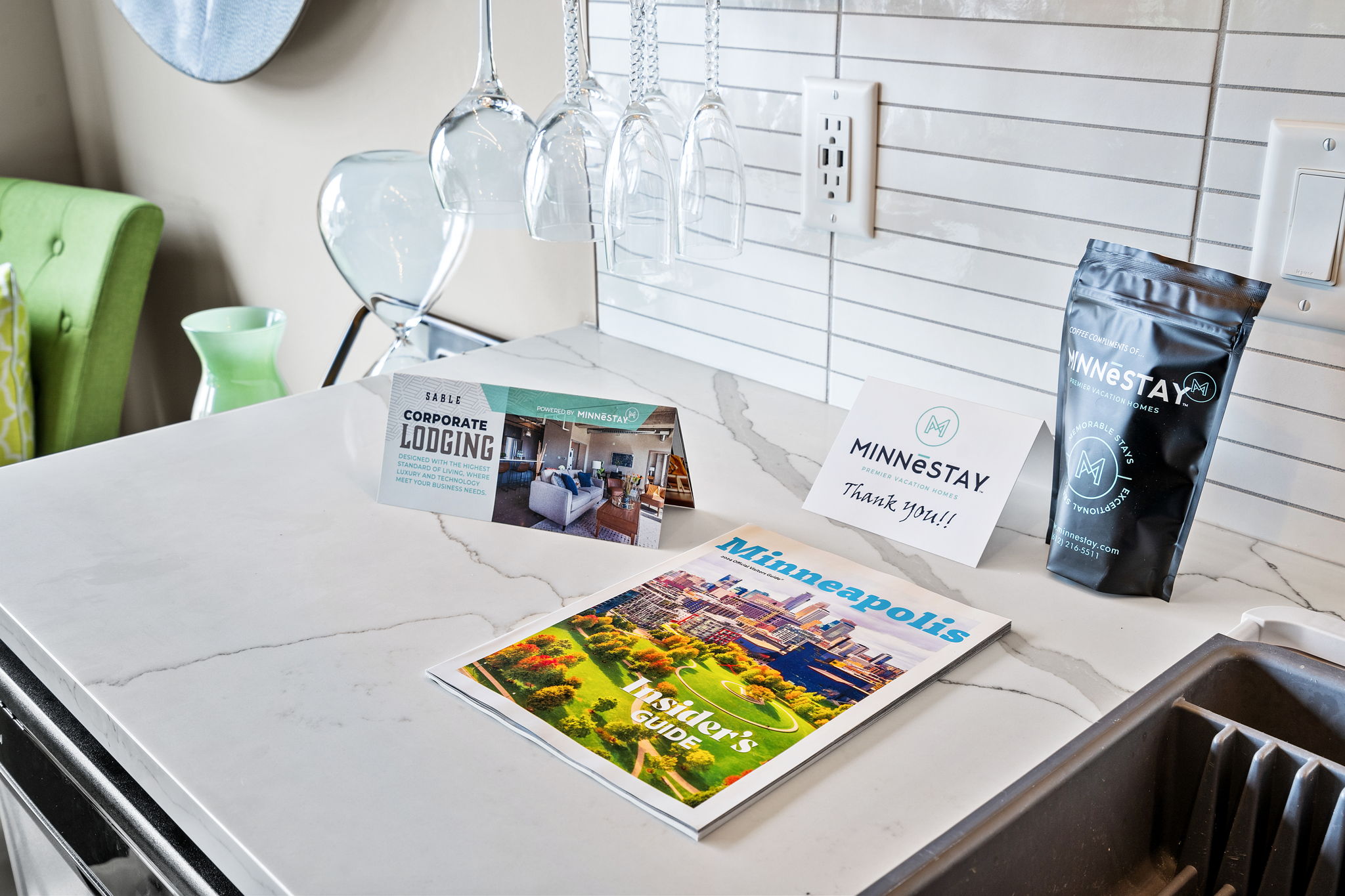 A stylish kitchen countertop featuring accommodations brochures and a coffee gift.