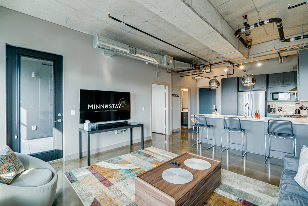 Stylish modern apartment living area with kitchen and seating.