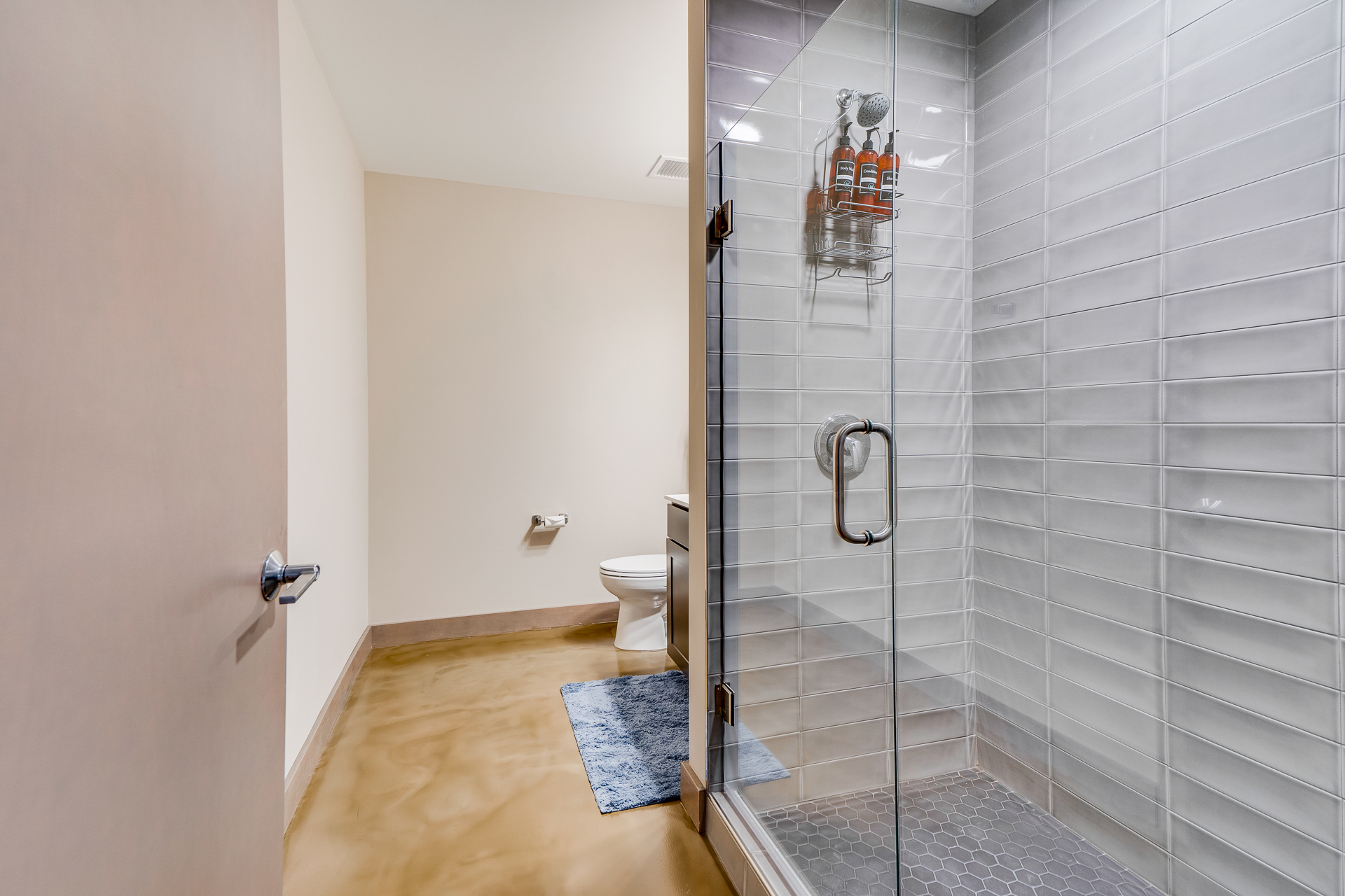 A modern bathroom featuring a glass shower and stylish decor.