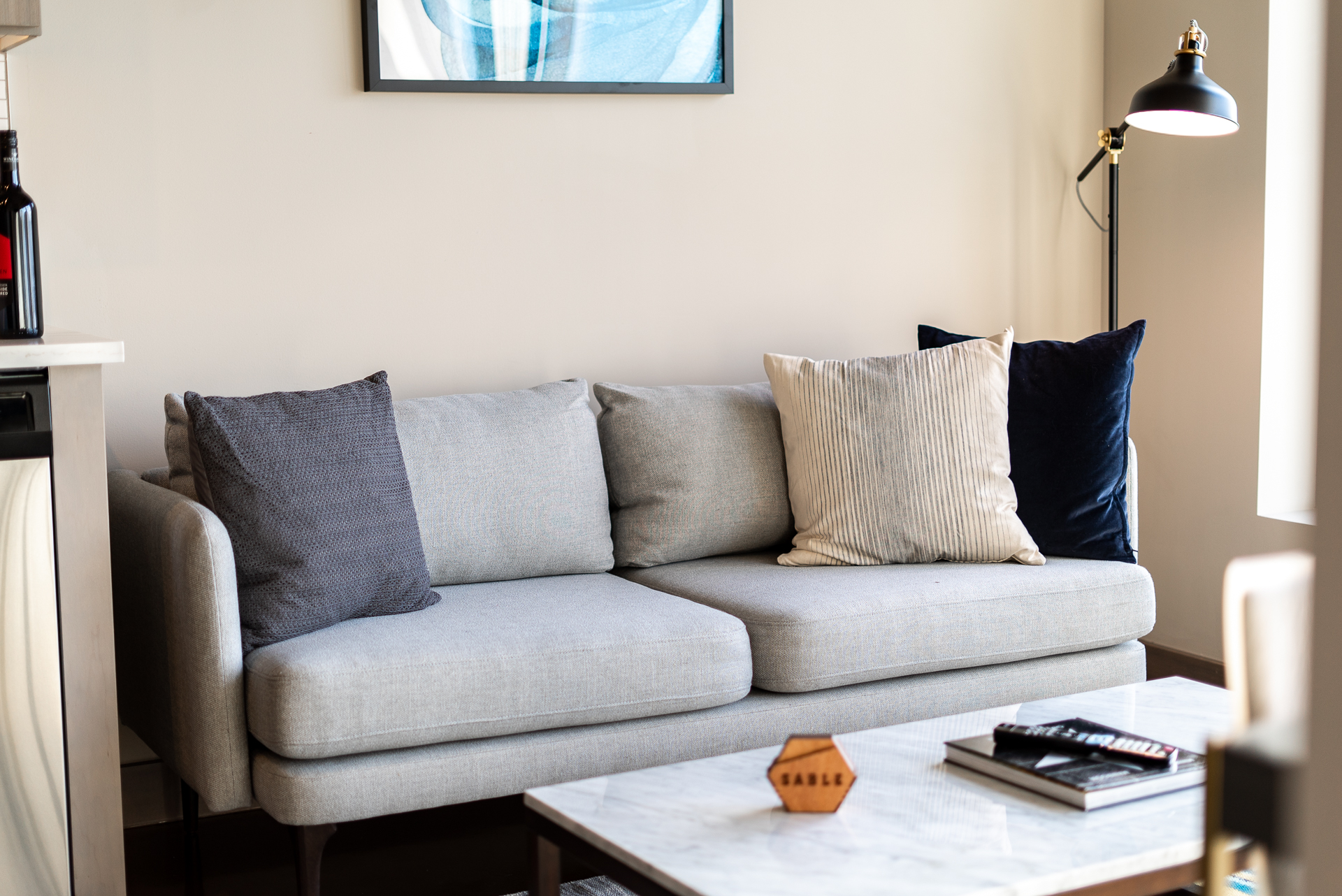 A modern living room with a cozy gray sofa and decorative pillows.