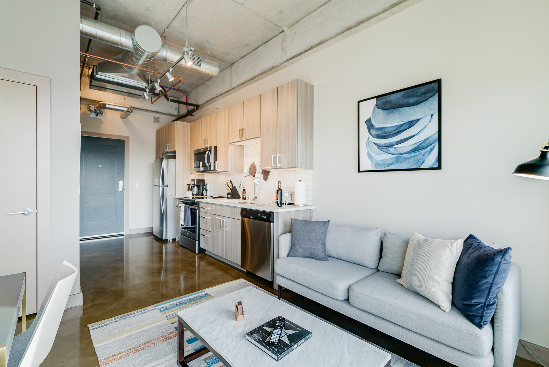 A modern and stylish living space with an integrated kitchen and cozy seating area.