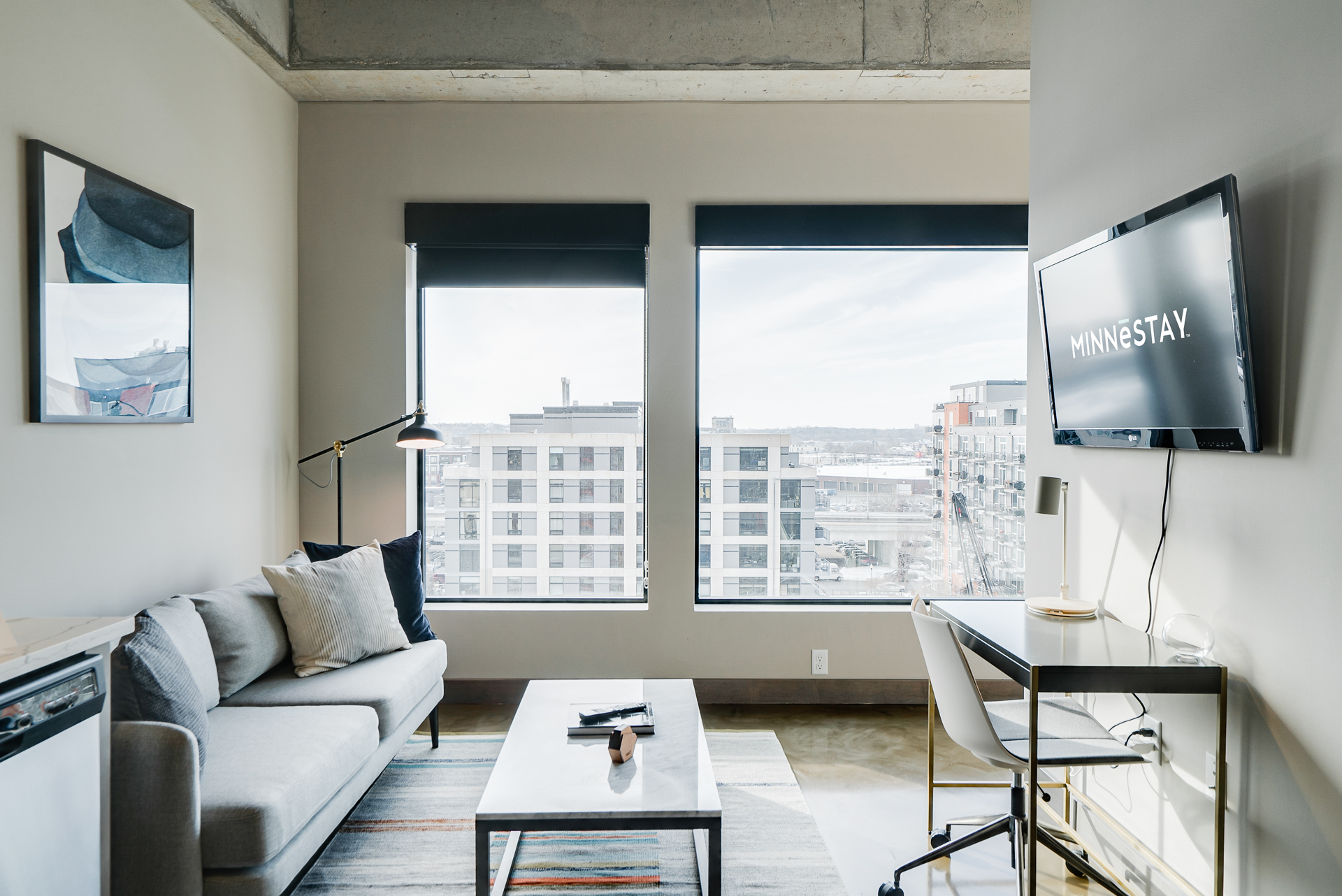 A modern urban apartment interior featuring a cozy living area and a view of the city.
