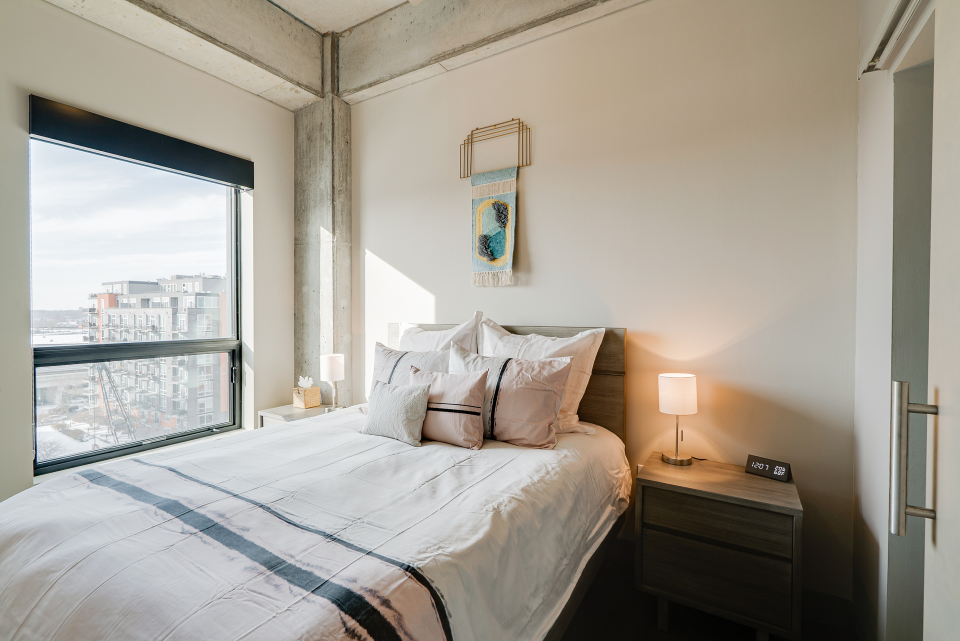 A modern bedroom with sleek design and an urban view.