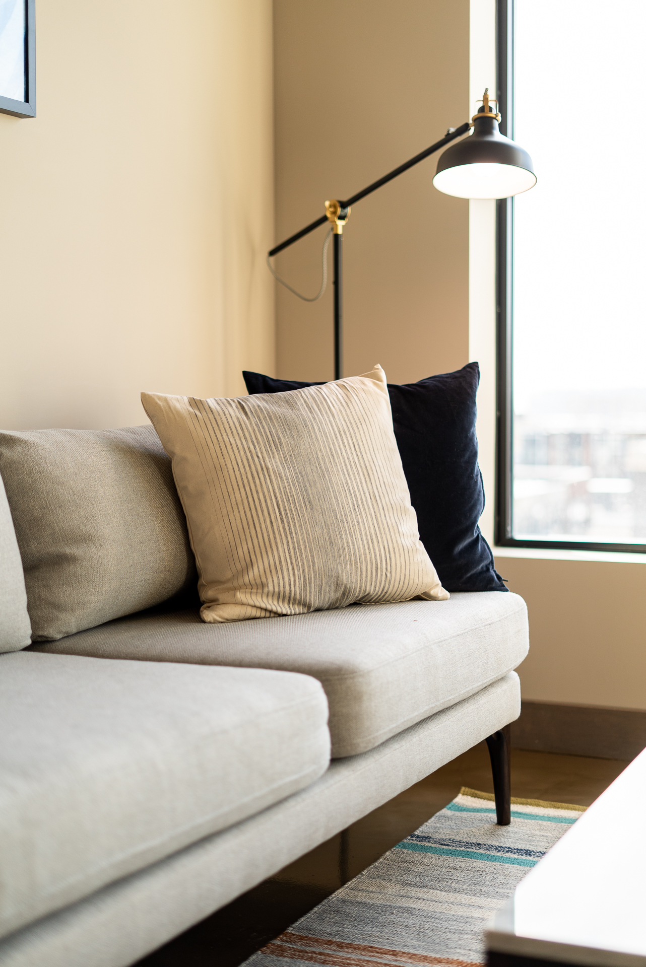 A cozy corner of a modern living room featuring a stylish sofa and warm lighting.