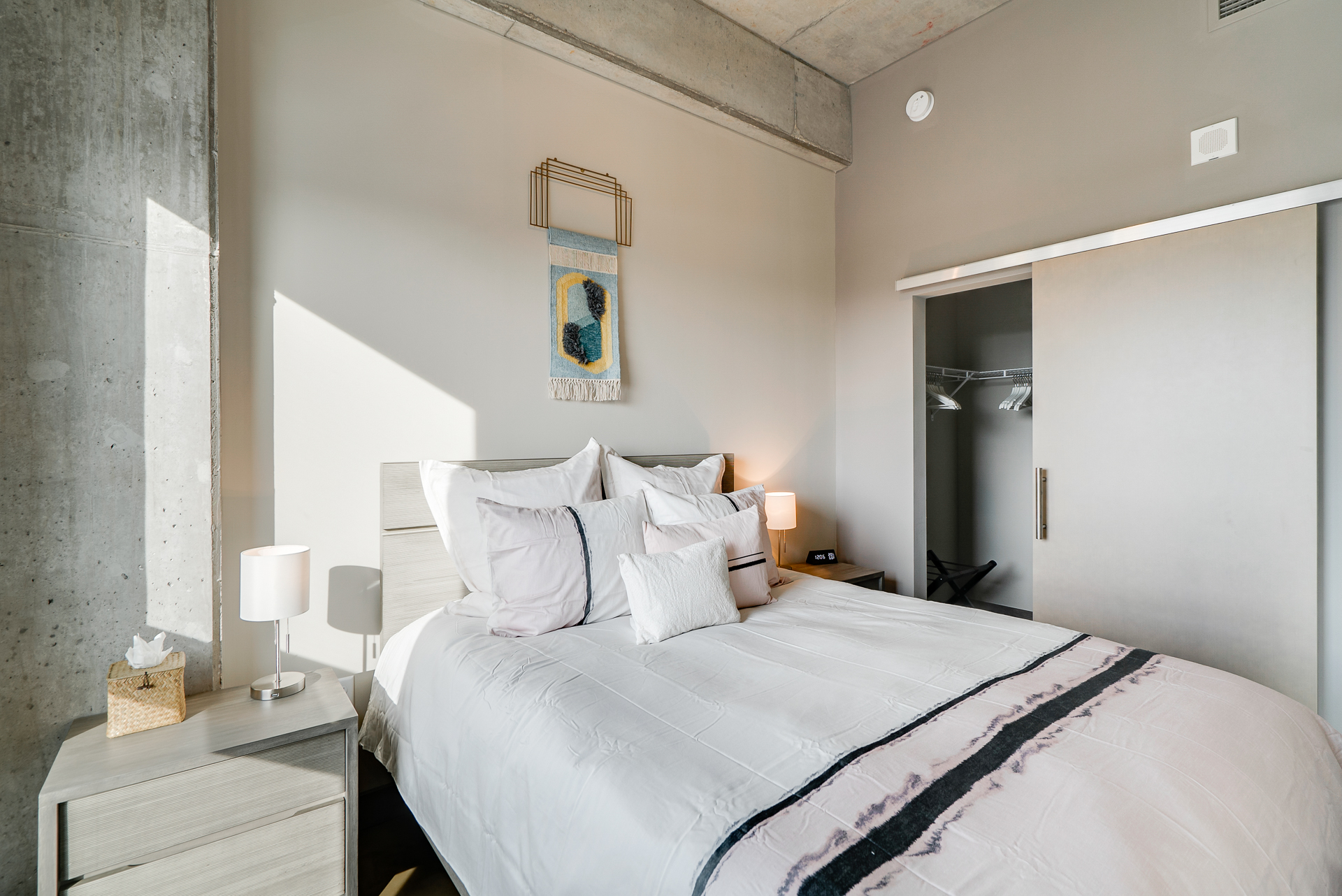A modern, elegantly designed bedroom featuring a comfortable bed and warm ambient lighting.