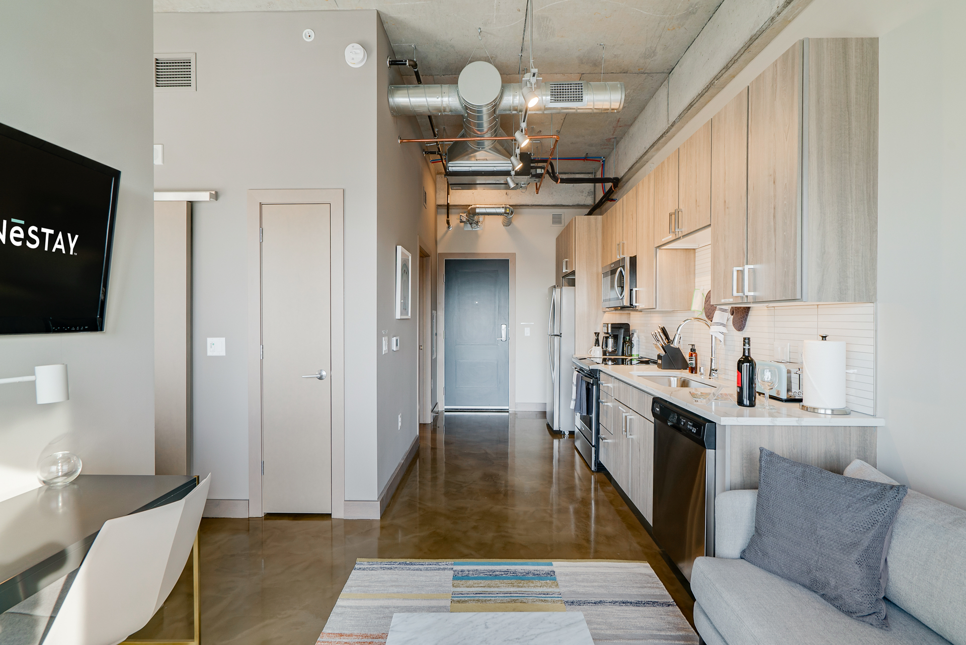 A stylish modern apartment showcasing a contemporary kitchen and living area.