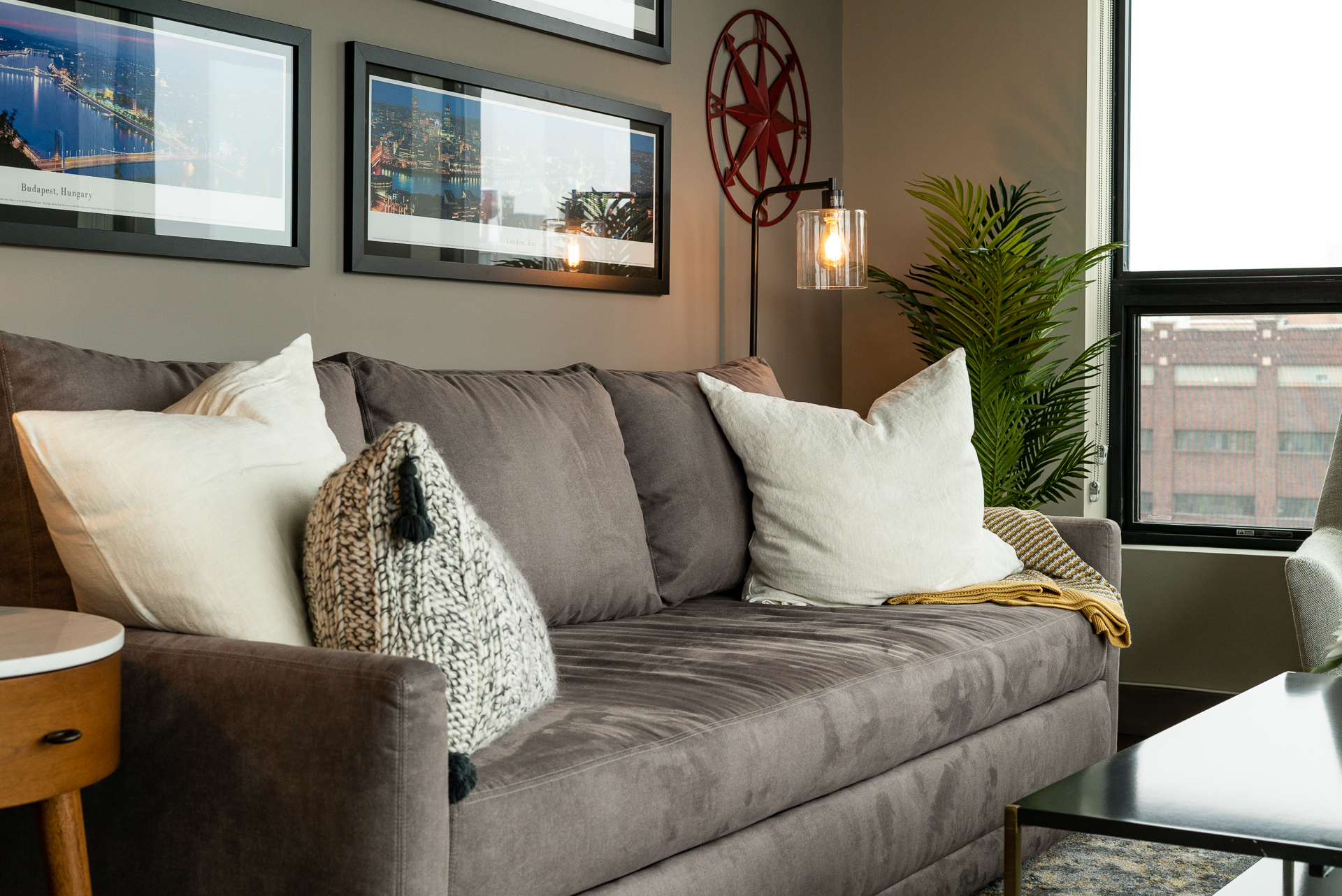 A cozy living room featuring a plush grey sofa and stylish decor.