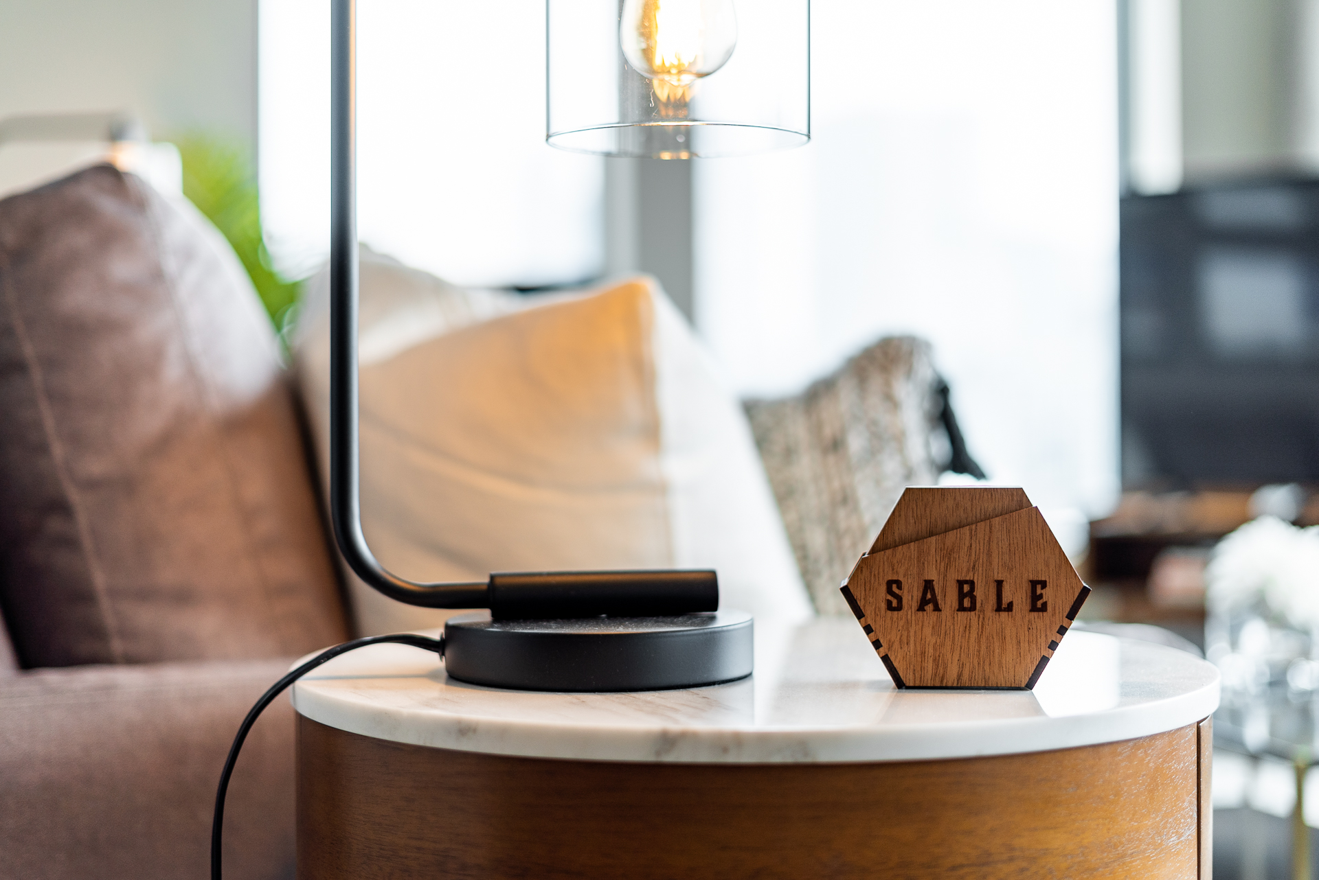 A stylish lamp and engraved wooden piece enhance a cozy living space.