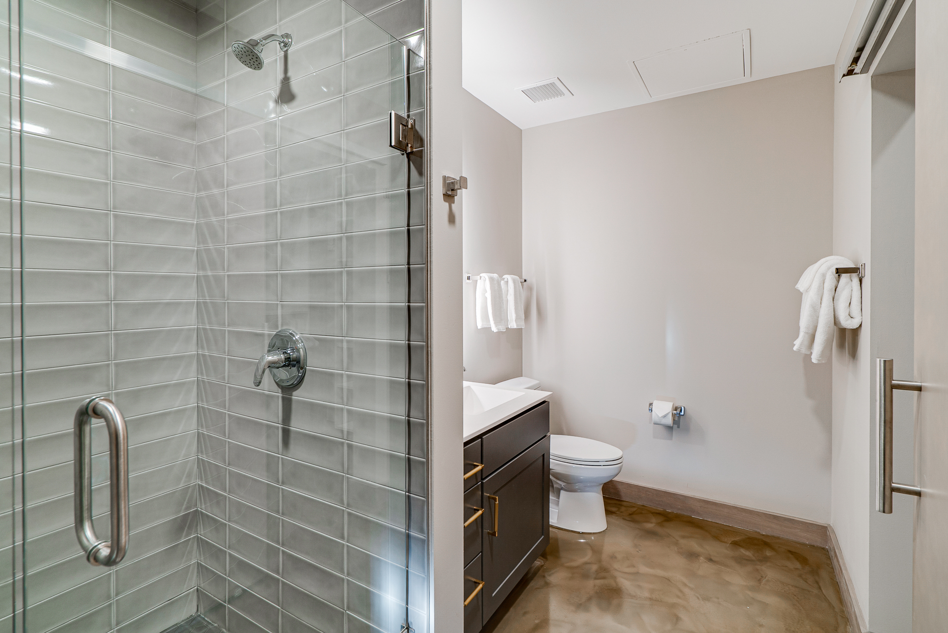 A modern bathroom featuring a walk-in shower and a sleek vanity.
