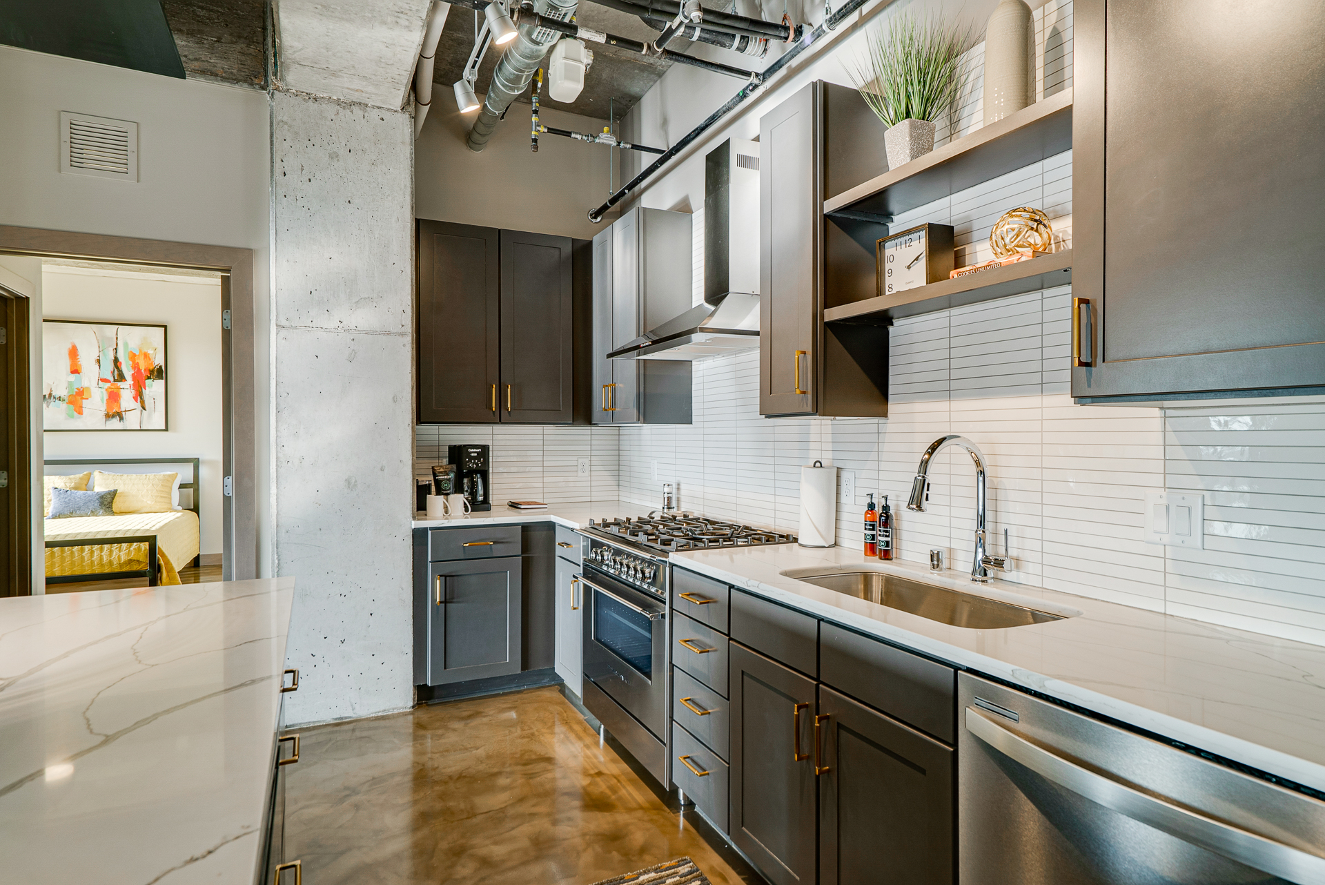 A stylish modern kitchen with dark cabinetry and elegant marble countertops.