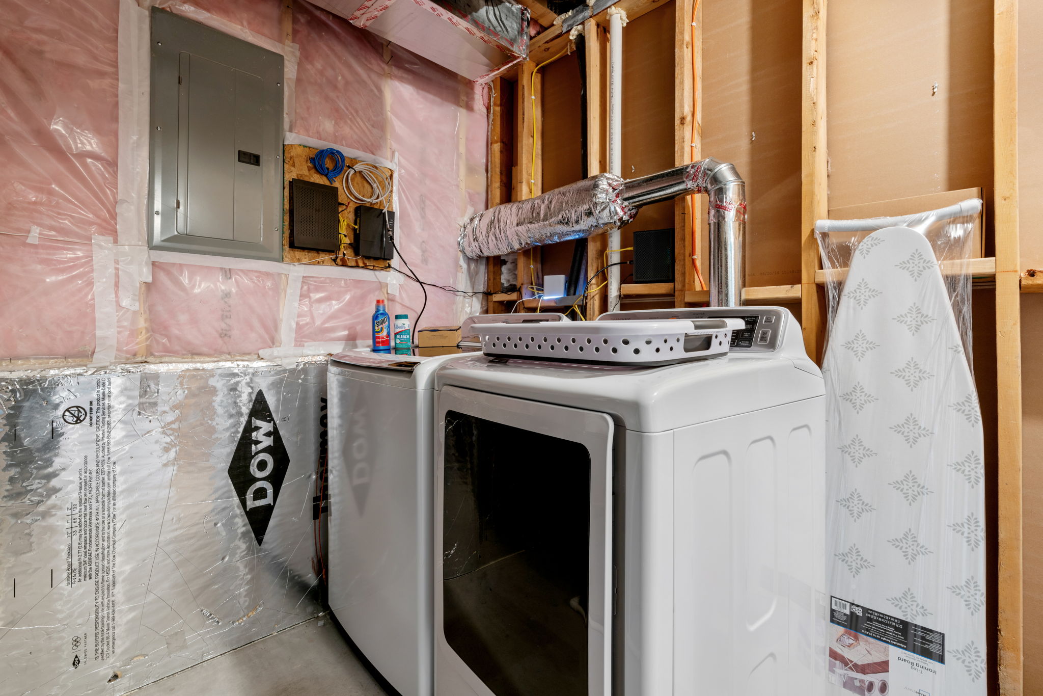 A modern laundry area featuring a dryer and washer in a basement setting.