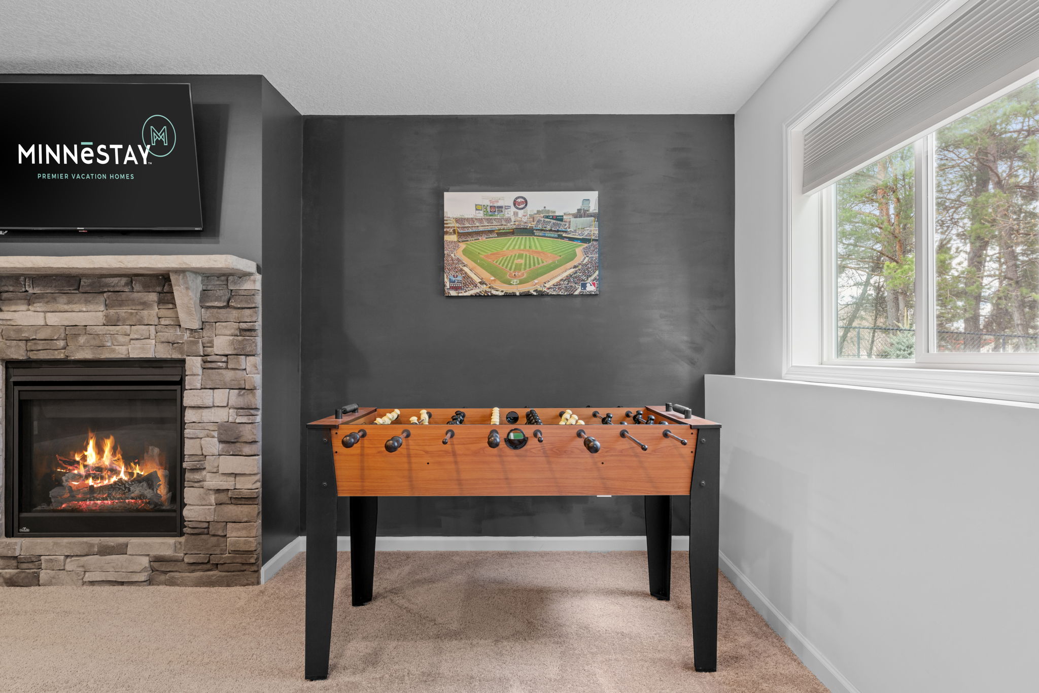 Cozy game room with foosball table and a warm fireplace.